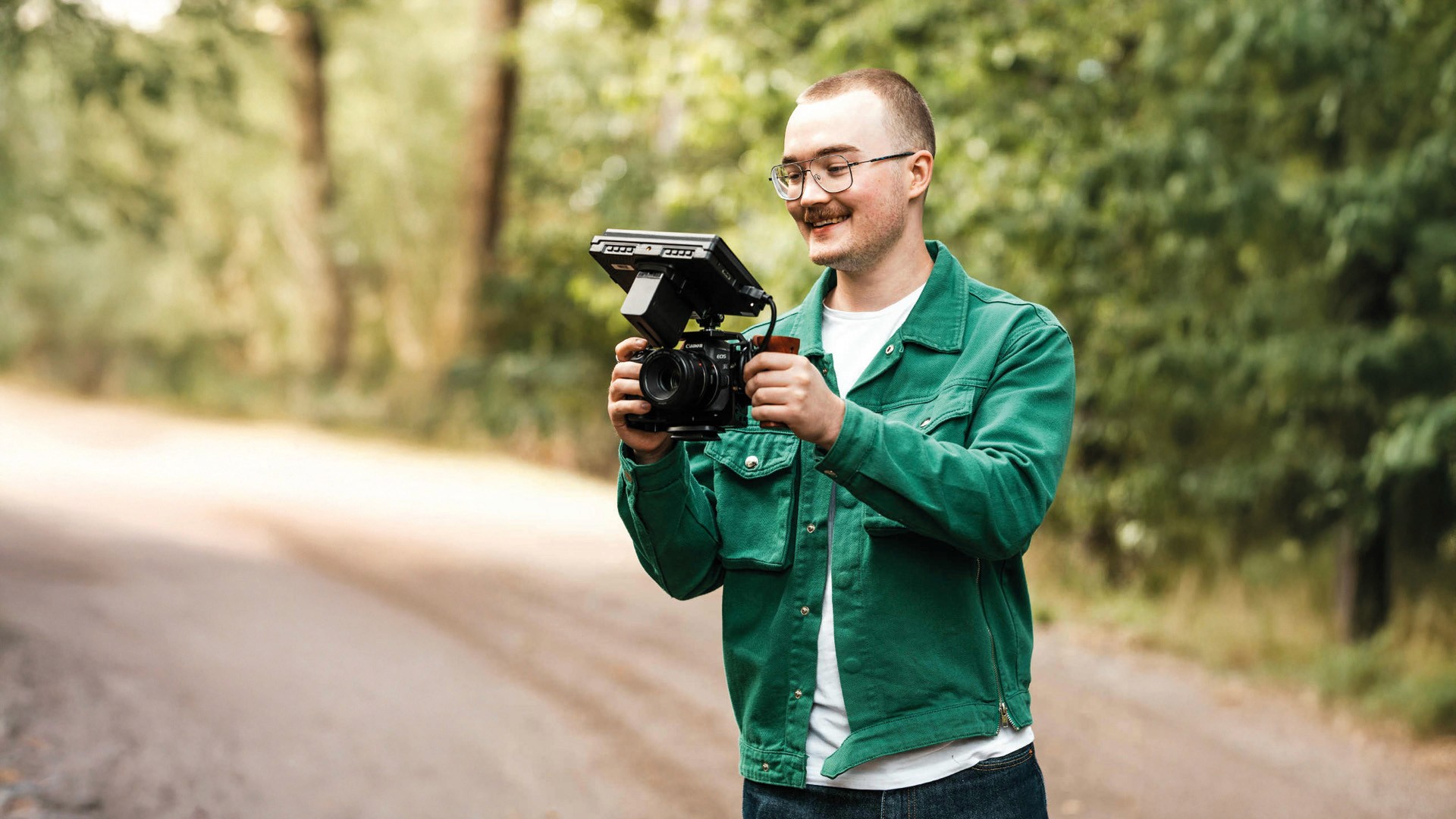 Fotograf går med sin kamera i handen.