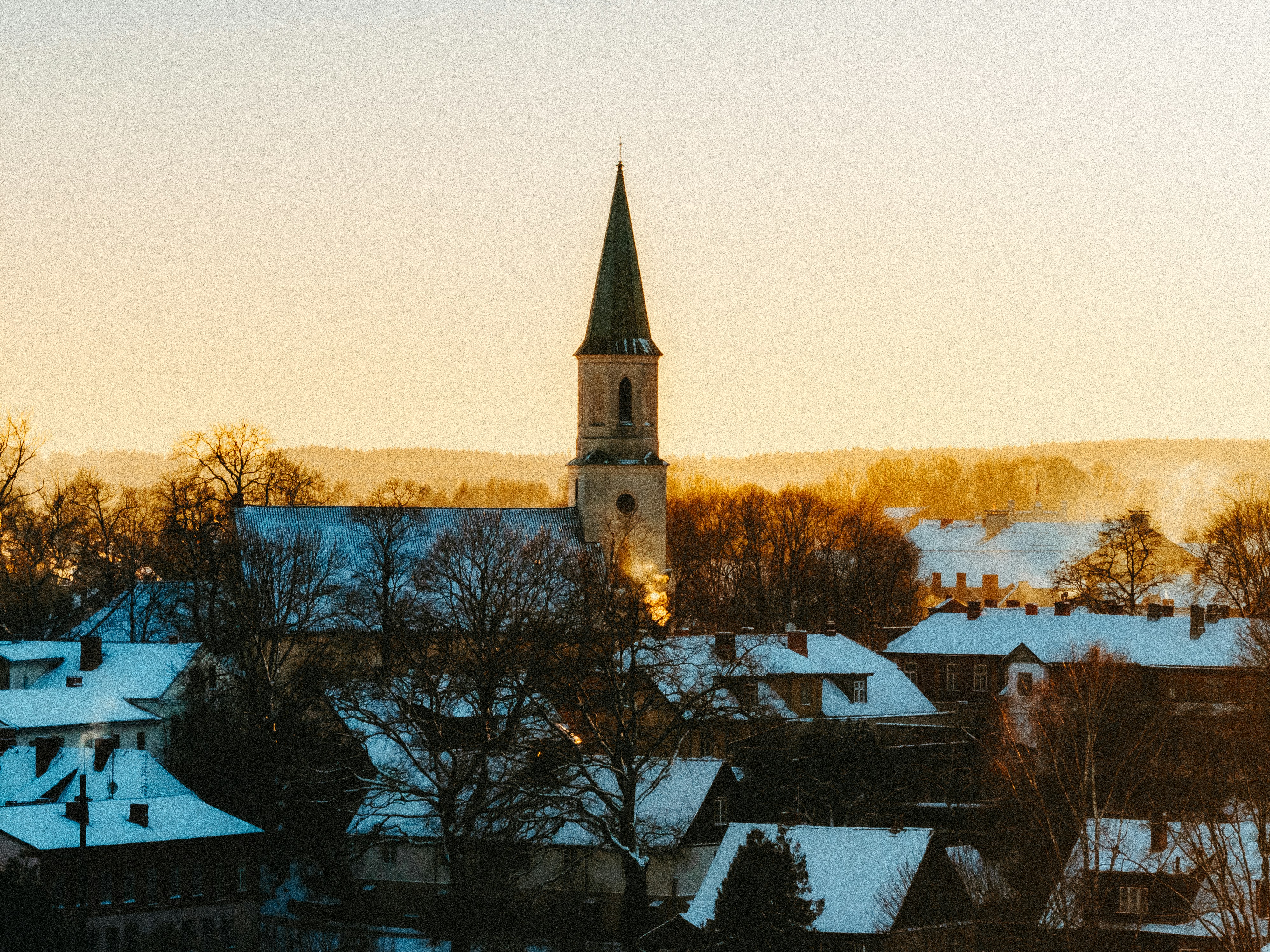 Snow-covered village with a church at sunset