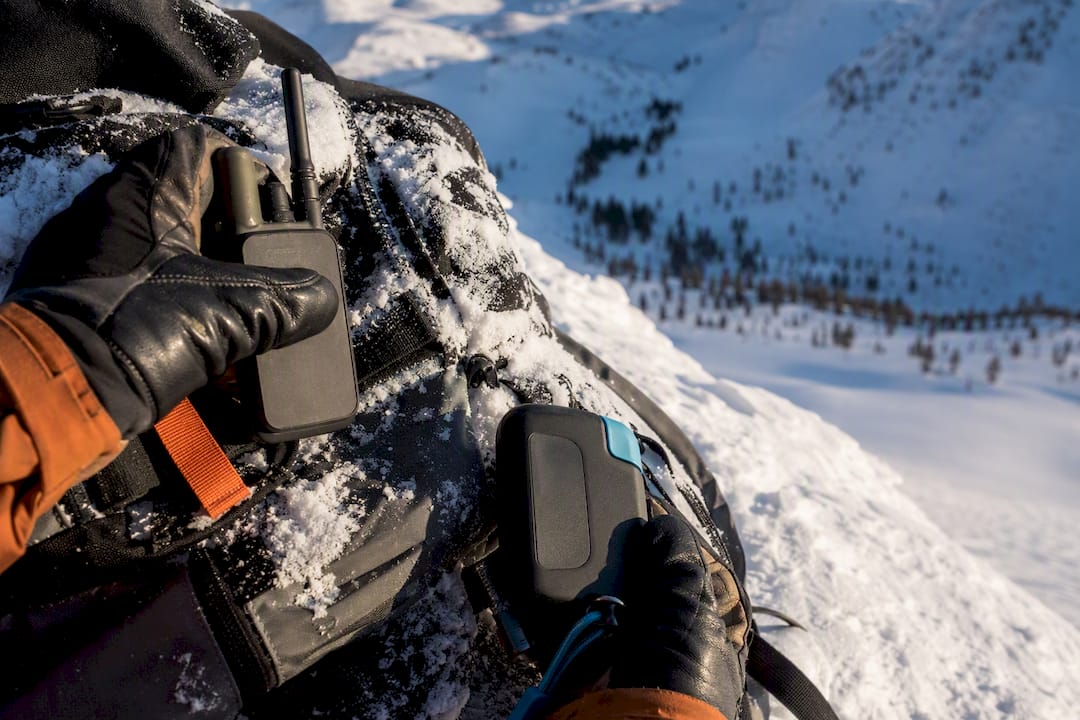 Handheld backcountry communication devices resting on snow