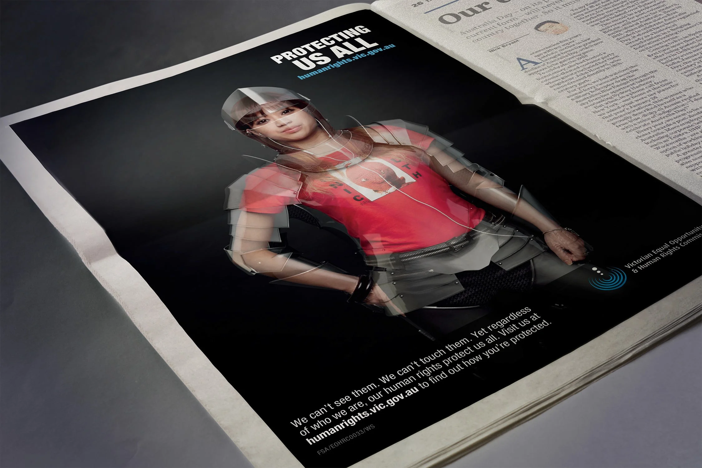 Newspaper ad 'Protecting us all' showing a young woman in a red T-shirt and translucent armour, with humanrights.vic.gov.au