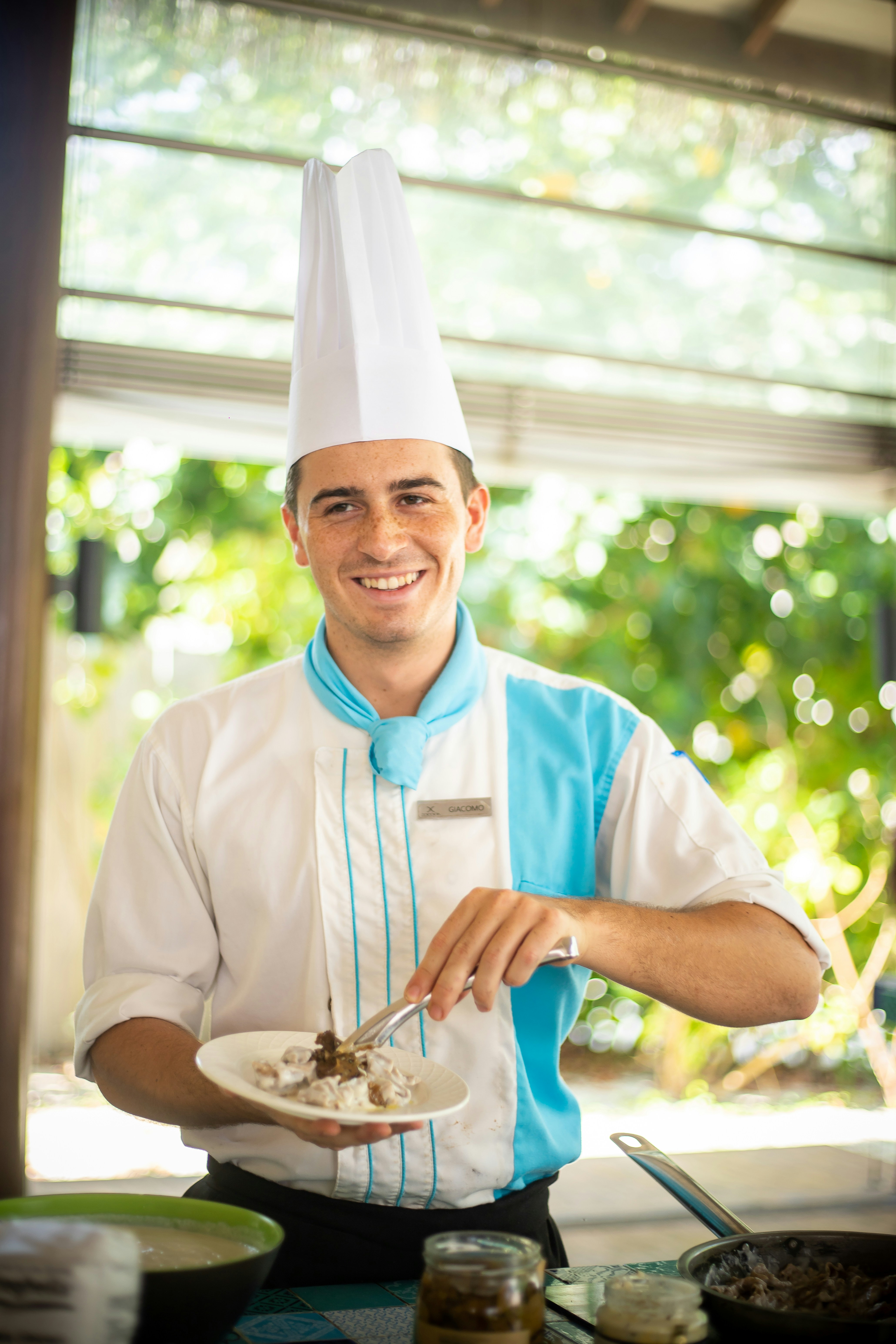 a man in a chef's hat holding a plate of food