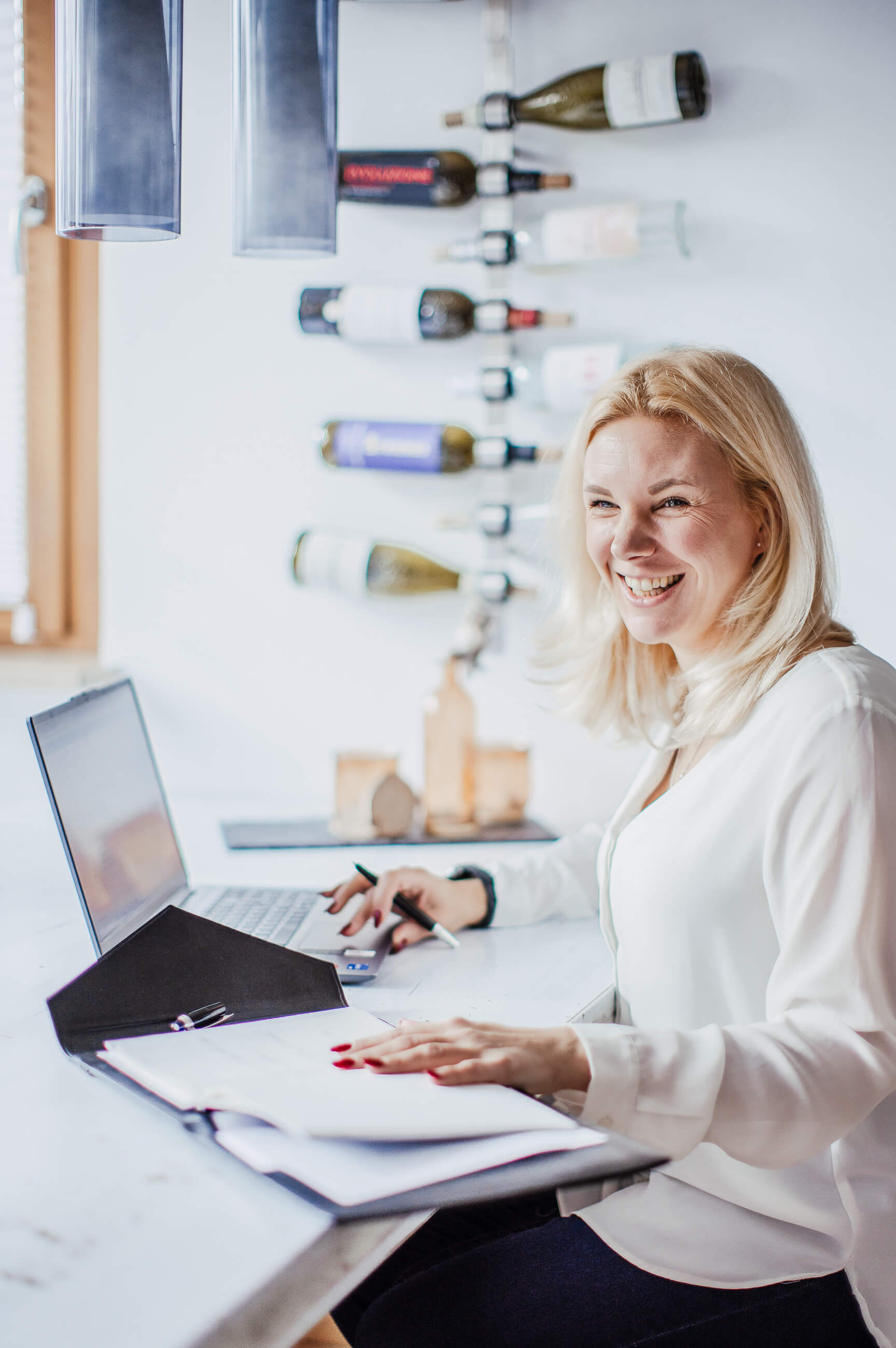 Theresa sitzt an ihrem Schreibtisch mit Laptop und lächelt, zeigt ihre entspannte und persönliche Arbeitsweise als HR-Copywriting-Expertin