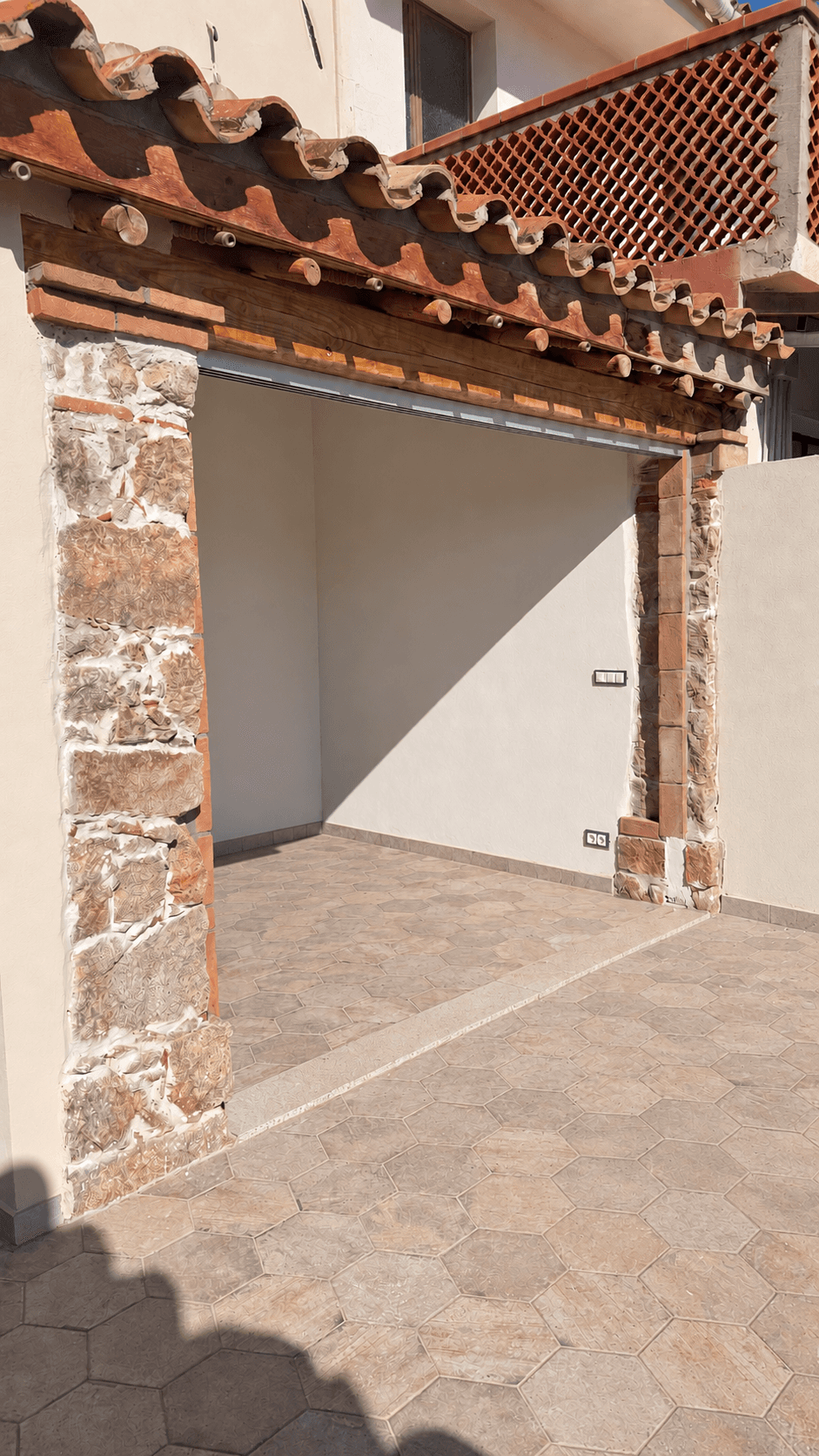 Portico a Muravera prima della posa dei vetri, con pilastri in pietra e copertura in legno.