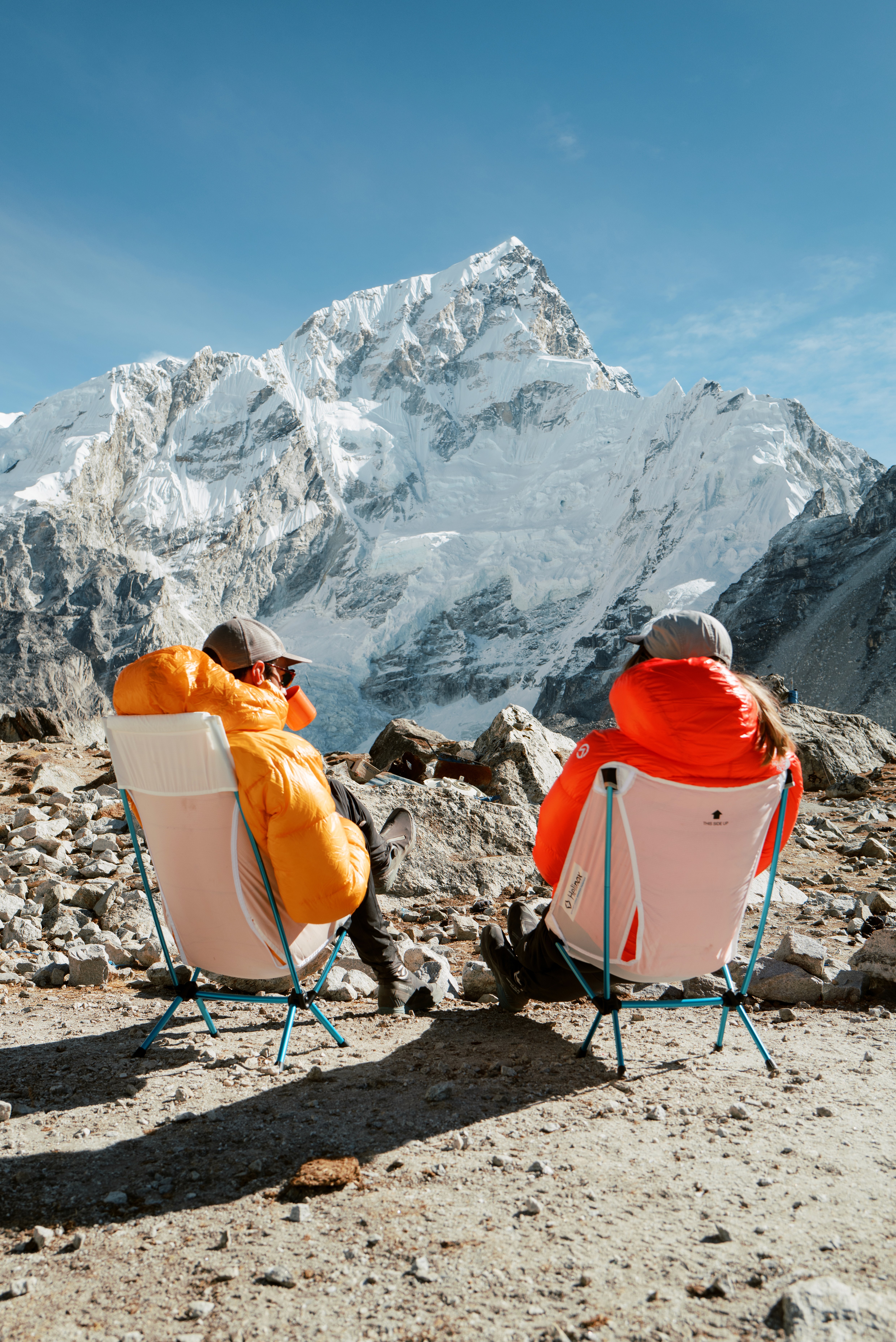 Deux personnes regardent l'Everest assises sur des chaises de camping pliantes Helinox