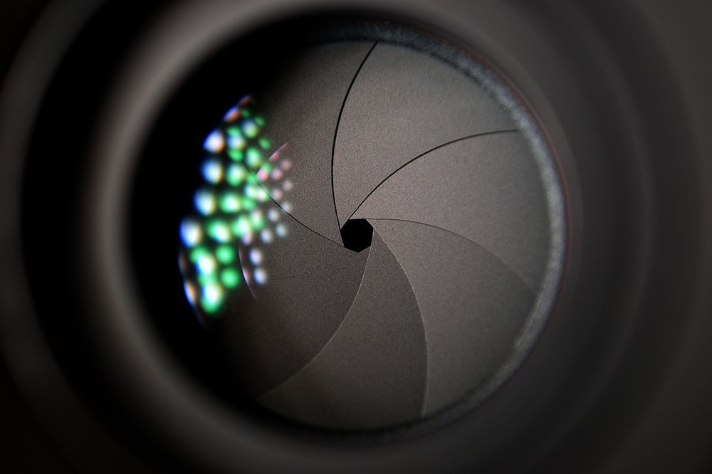 Close-up of a camera lens with a small aperture opening