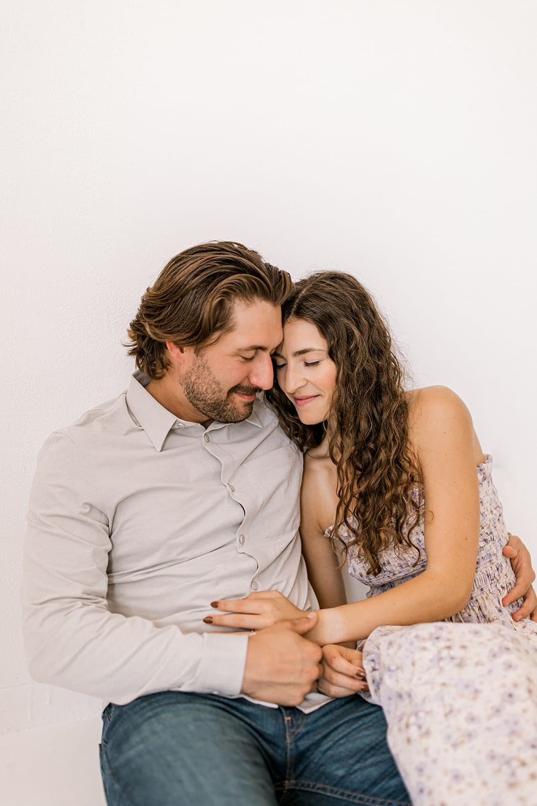 The couple lovingly sits together, the man kissing the woman’s forehead in a natural light photography session at Revelator Studio in Shreveport.