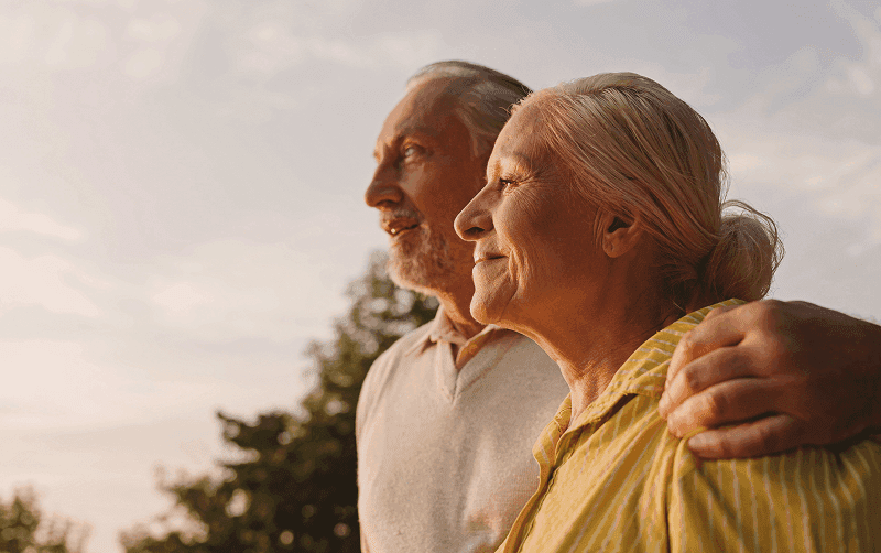 senior couple smiling as they hug