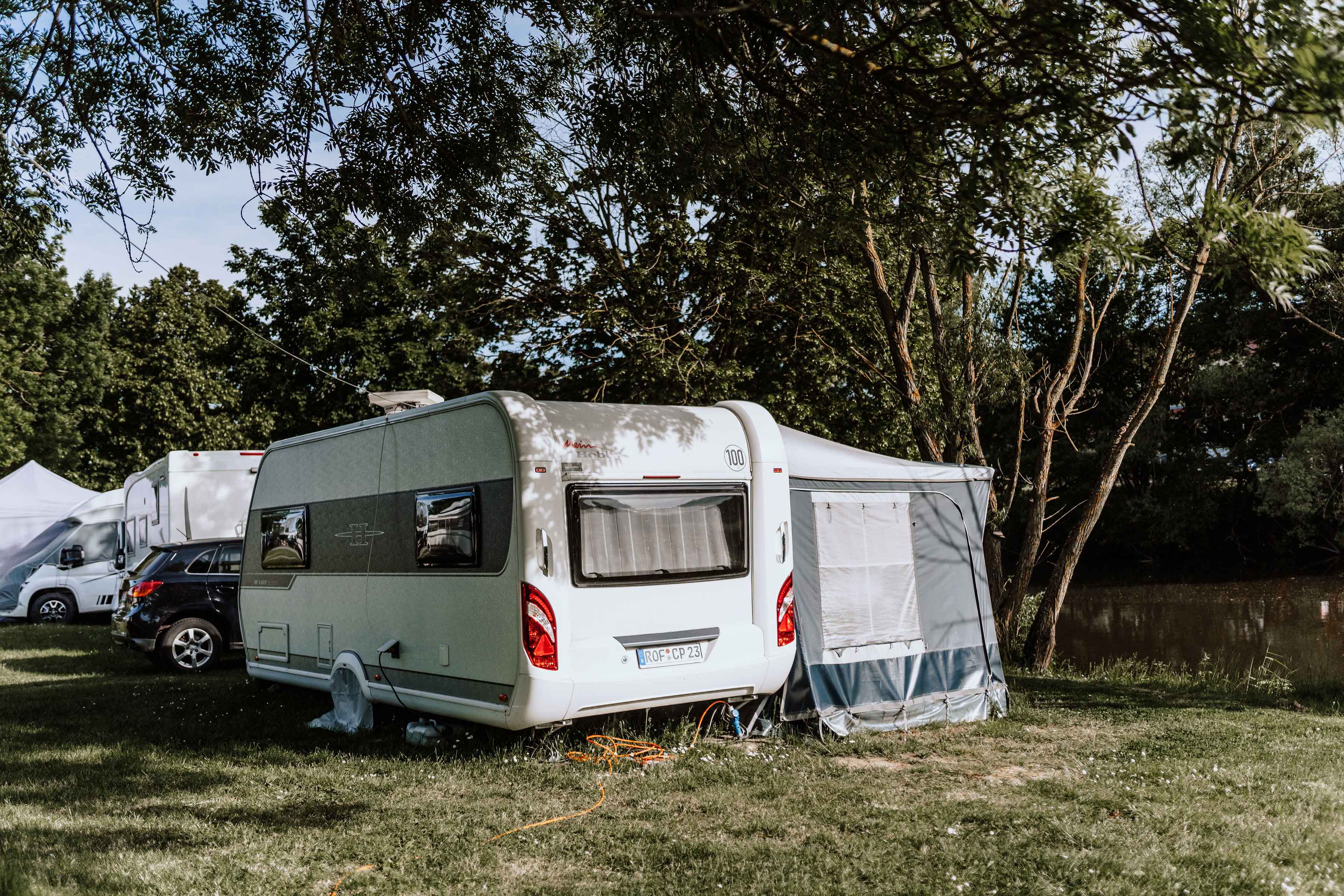 Mietwohnwagen von außen mit Tisch und Bank