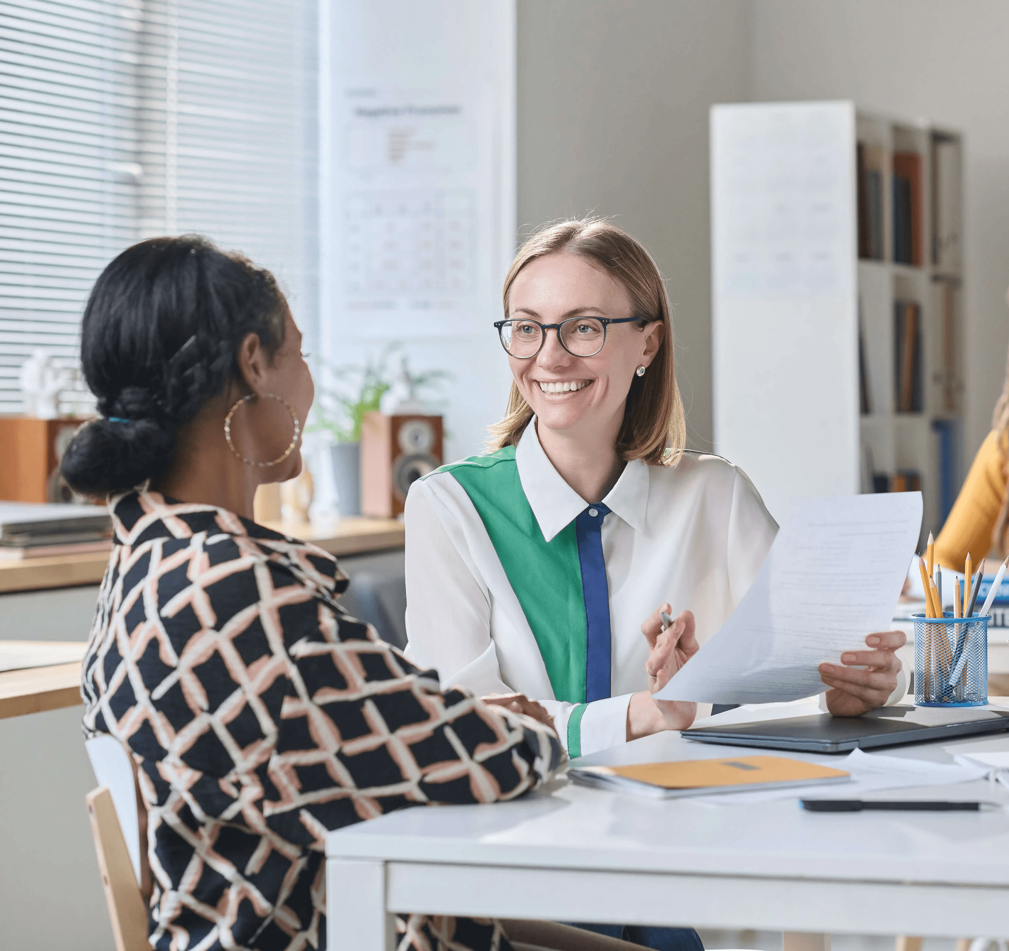 Children are sitting on the grass, reading a book together