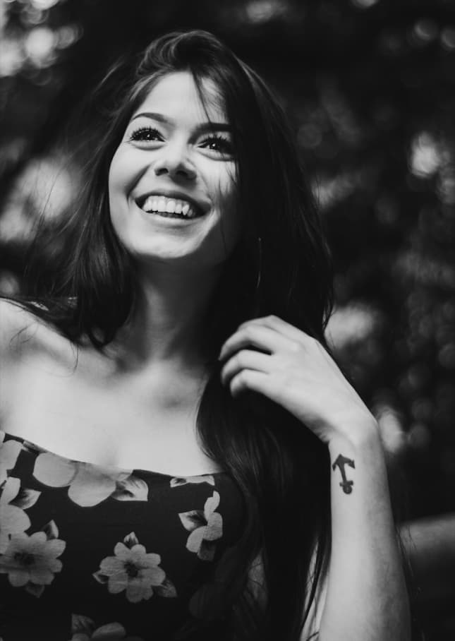 Black and white portrait of a smiling person with curly hair