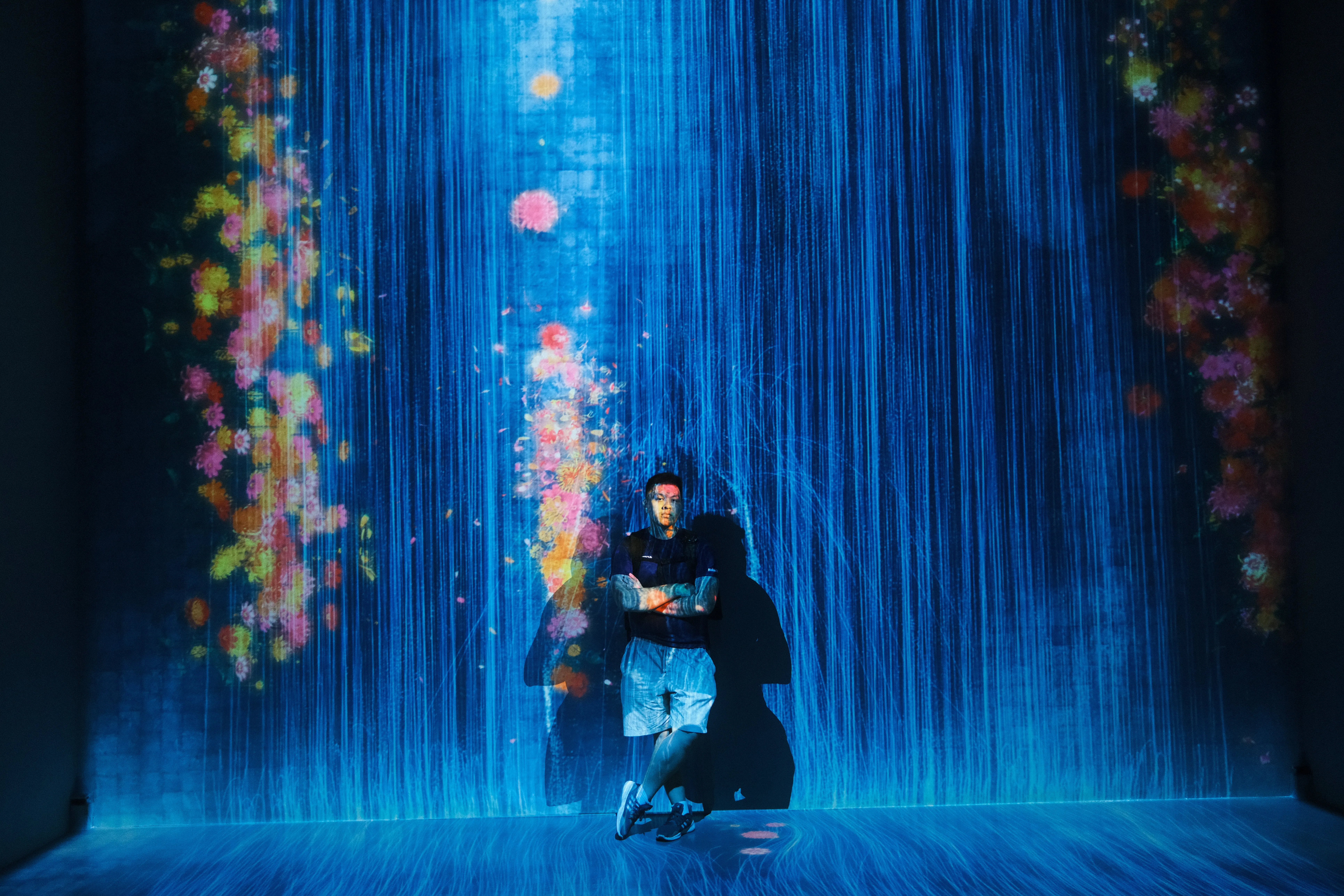 Figure standing inside an immersive blue light installation