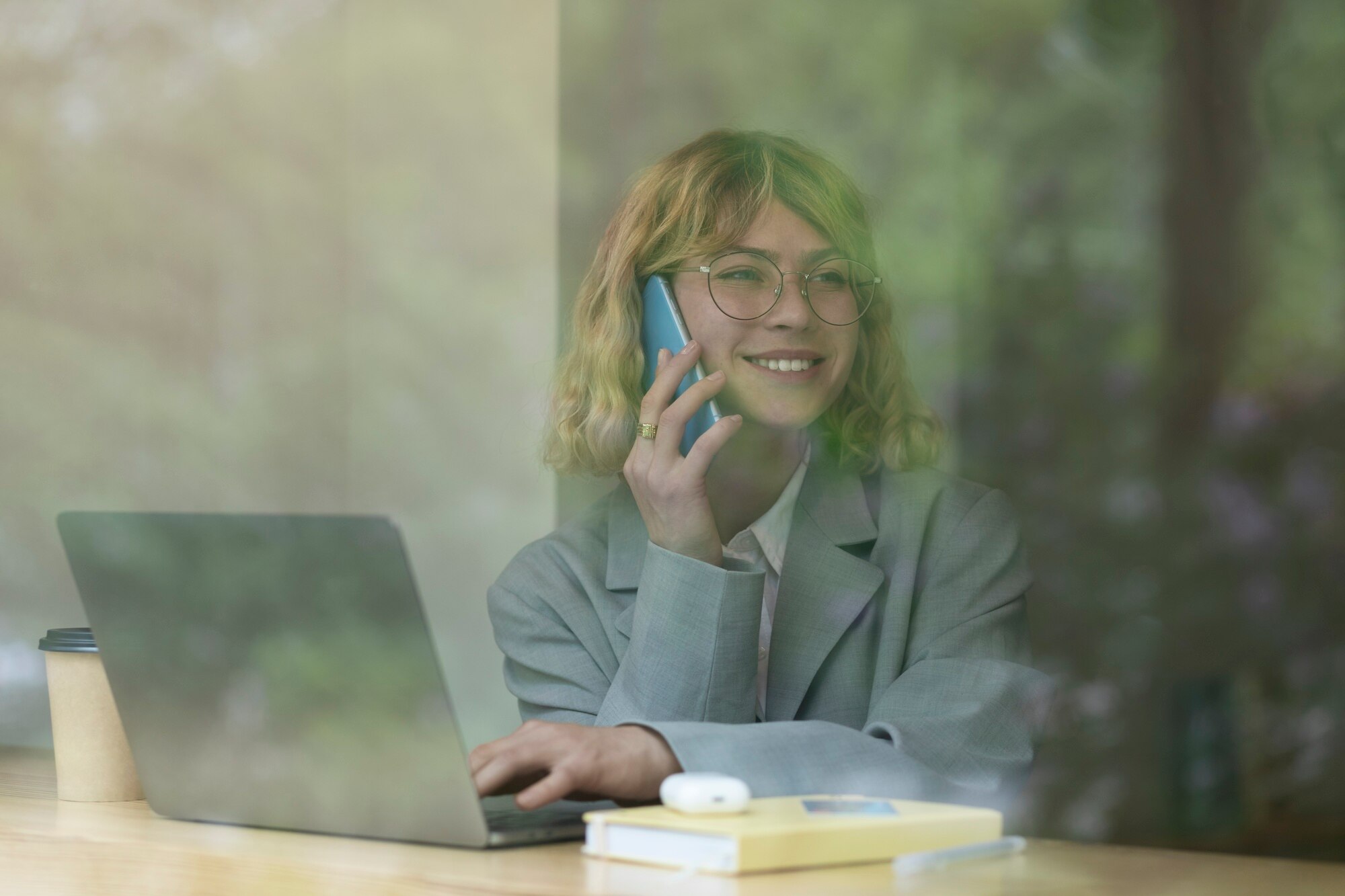 Vrouw aan de telefoon met laptop, bereikbaar via AI-receptionist buiten kantooruren