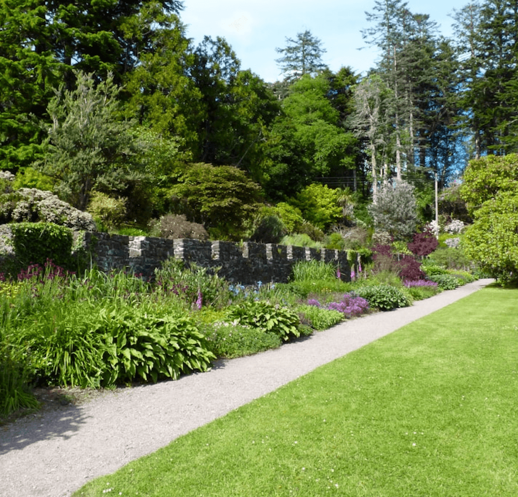 Colorful flower garden with cut lawn and stone walkway leading through