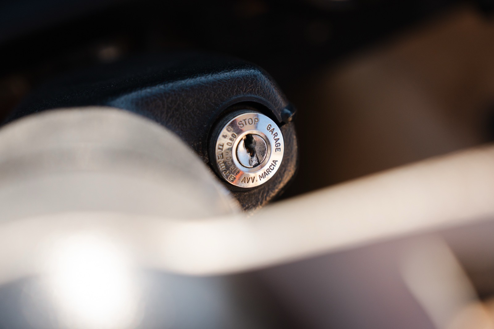 Close-up of a metallic screw or bolt with a circular head, partially surrounded by translucent material.