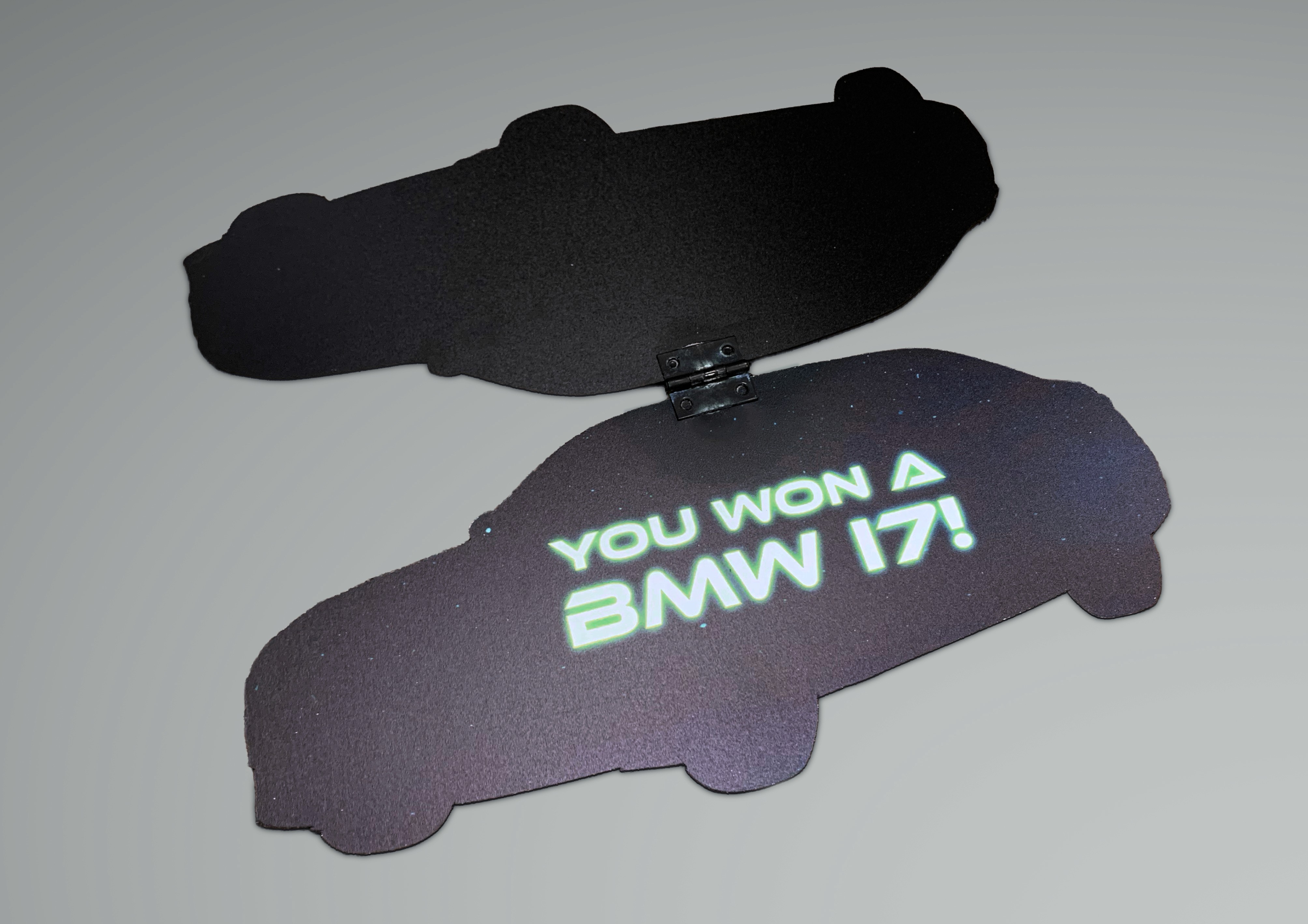 BMW i7 shaped prize opened, reading, "YOU WON A BMW i7!"
