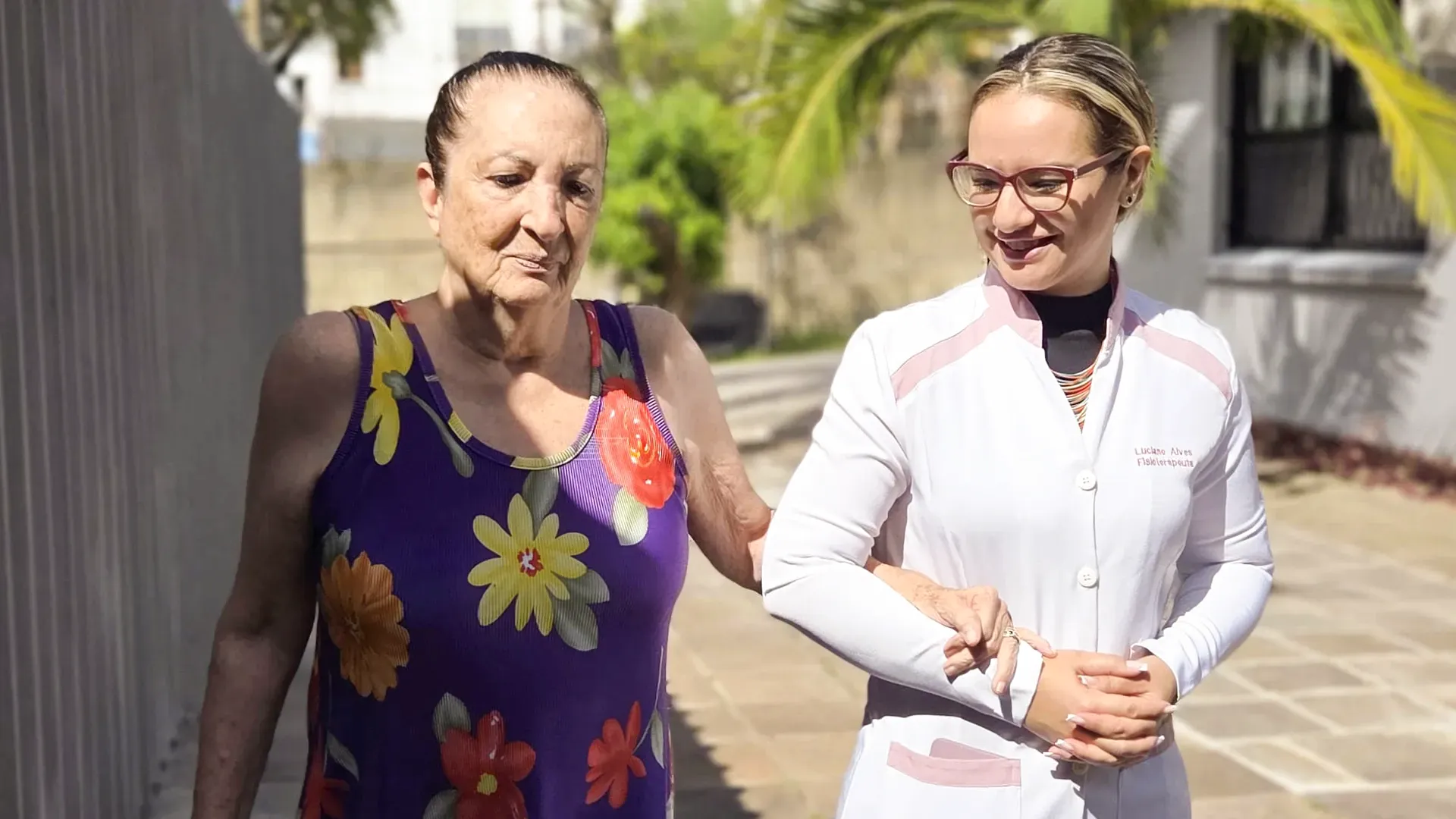 Close de um cuidador segurando gentilmente as mãos de uma idosa, simbolizando apoio e cuidado contínuo - Residencial Geriátrico Nova Era