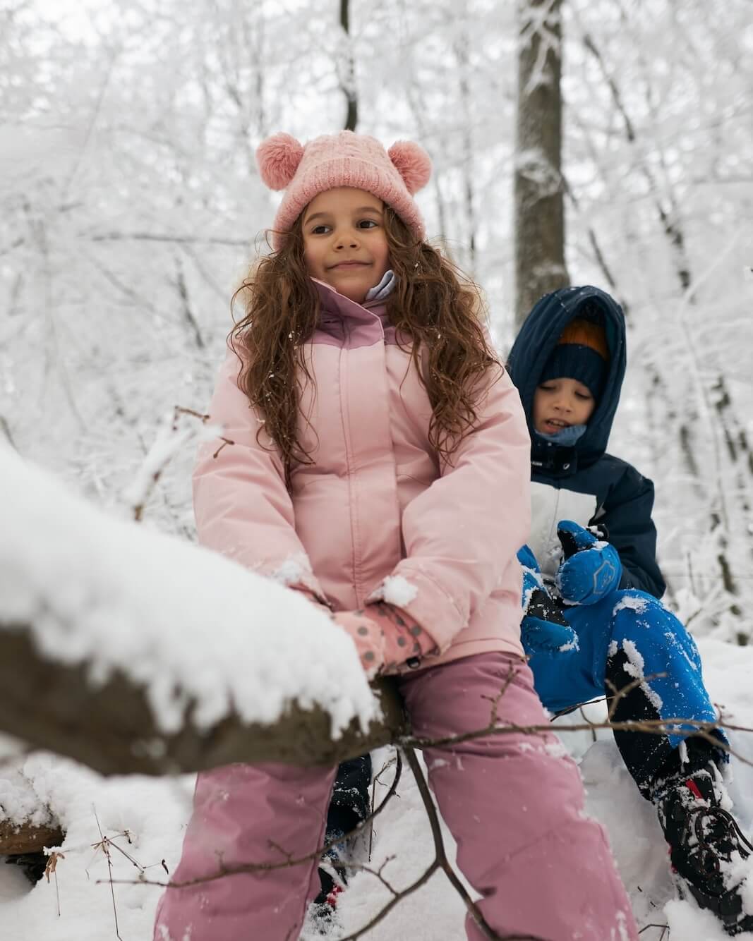 Long suspension bridge carrying pipelines over blue water towards industrial buildings.