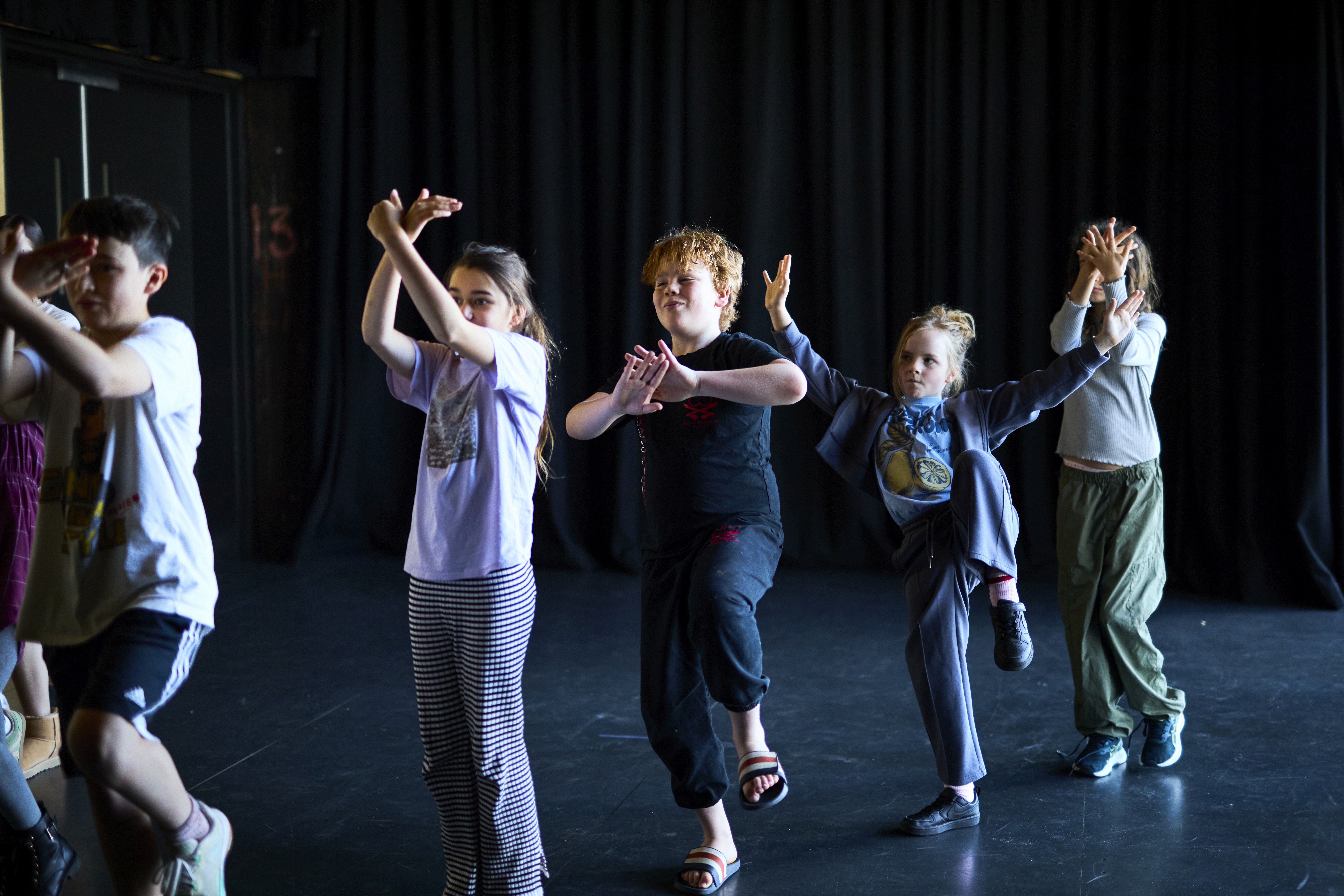 Children move and play through a room in a drama activity. 
