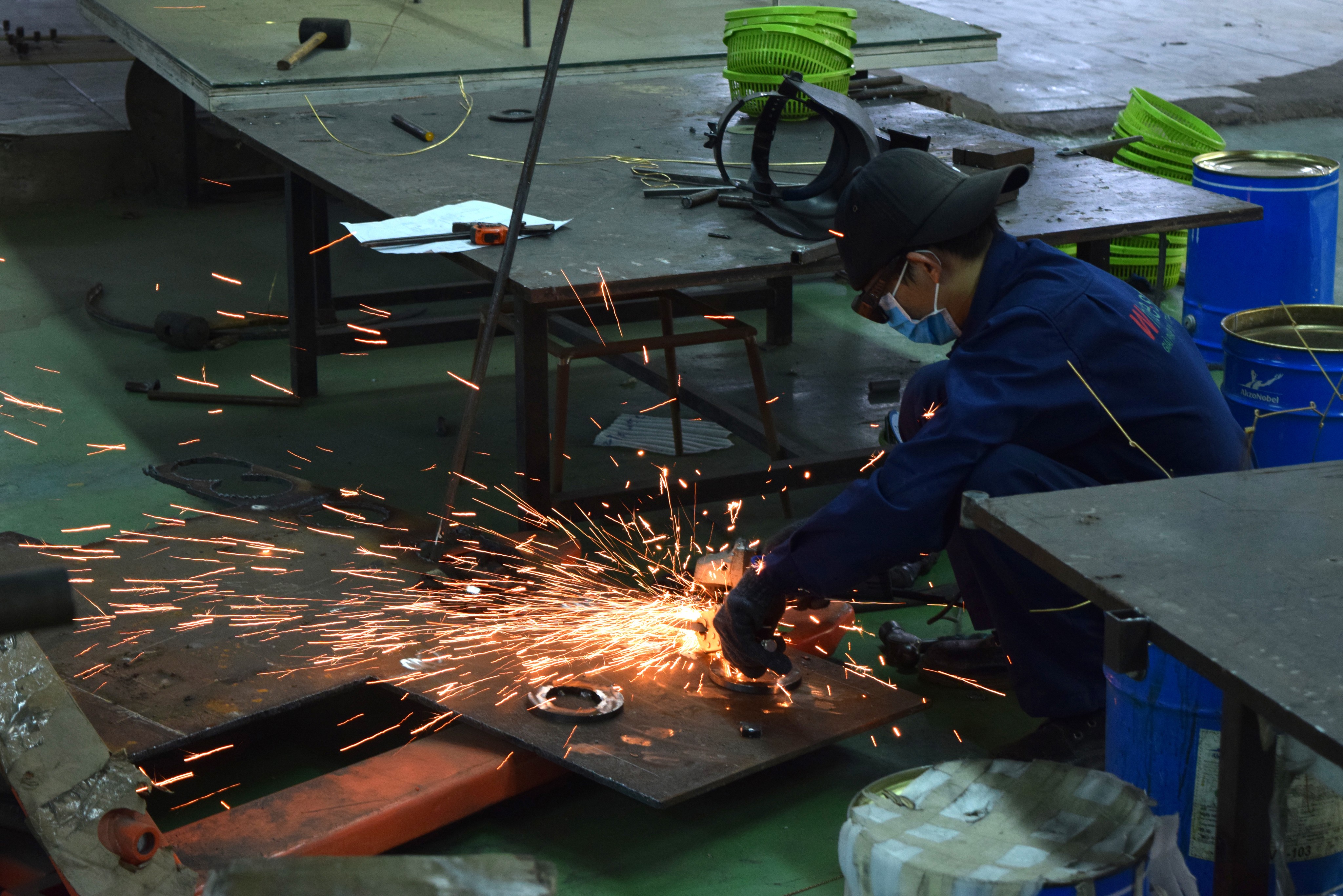 Vietnamese factory worker welding metal