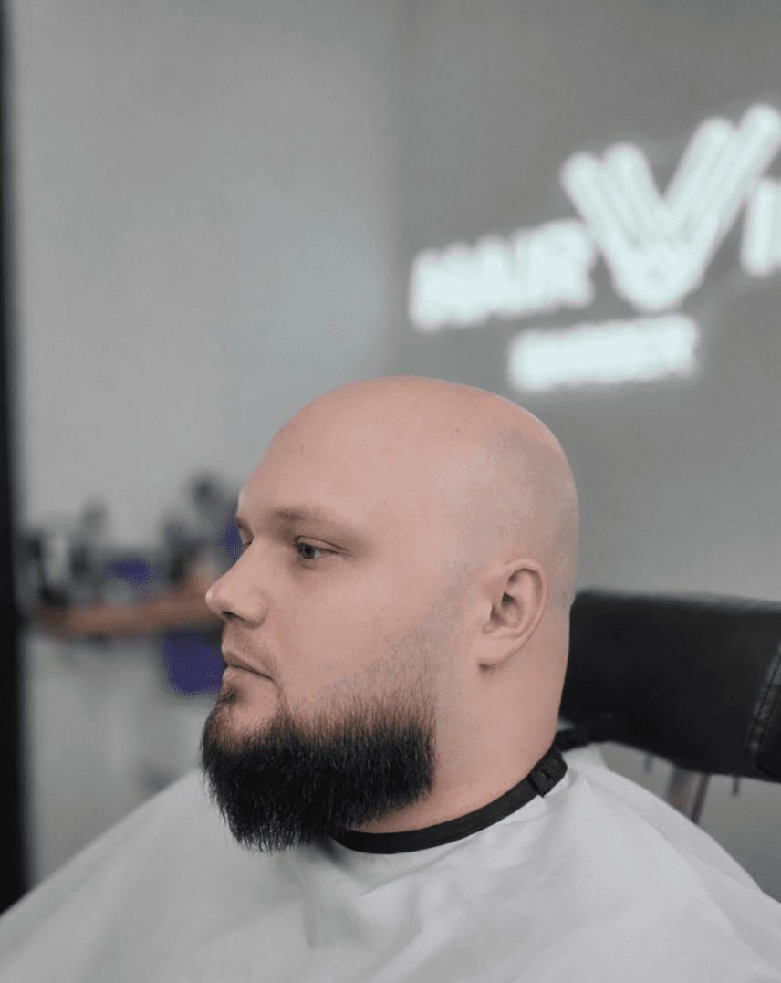 grayscale photography of person holding scissor clipping man's beard