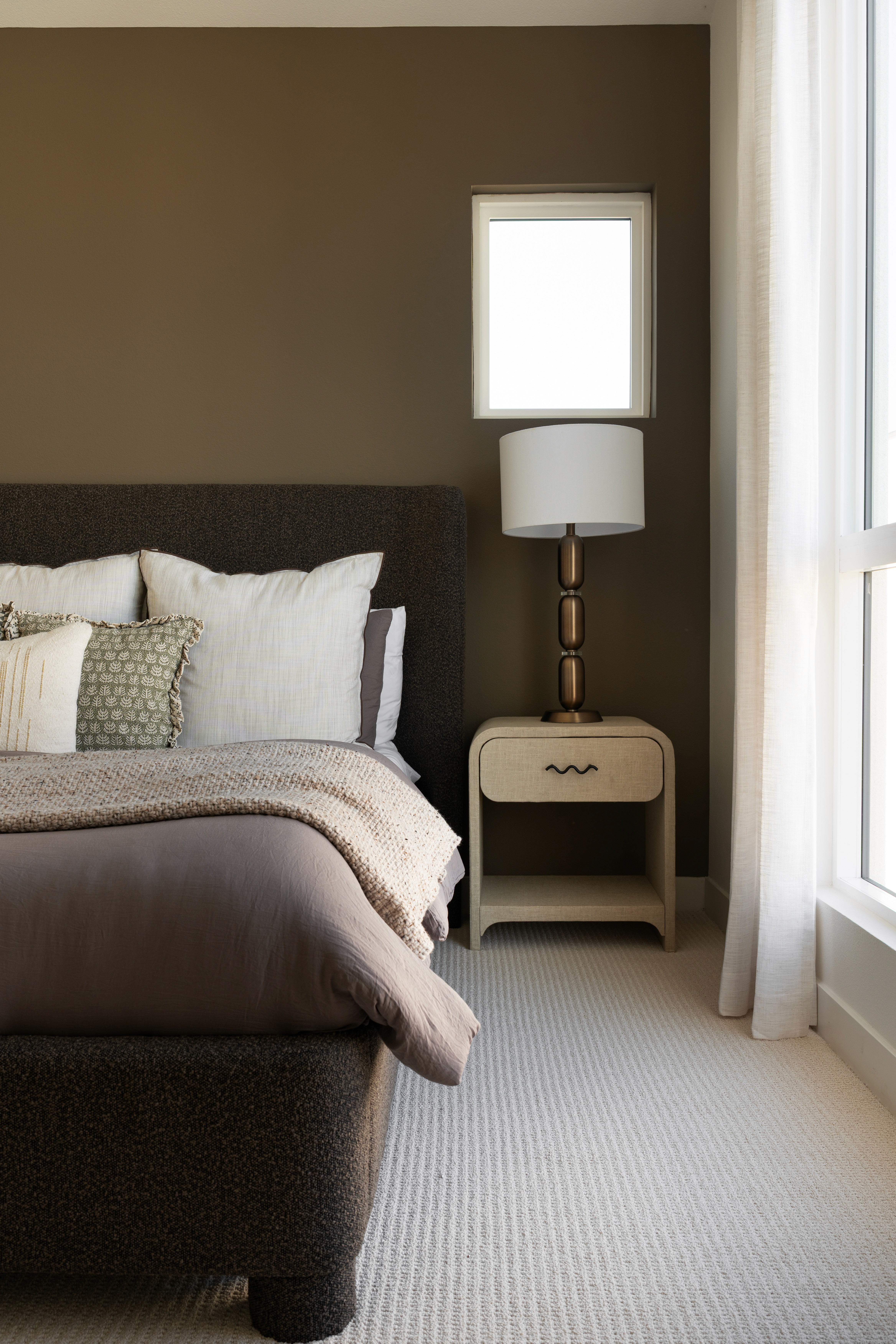 View of bed and side table of primary bedroom