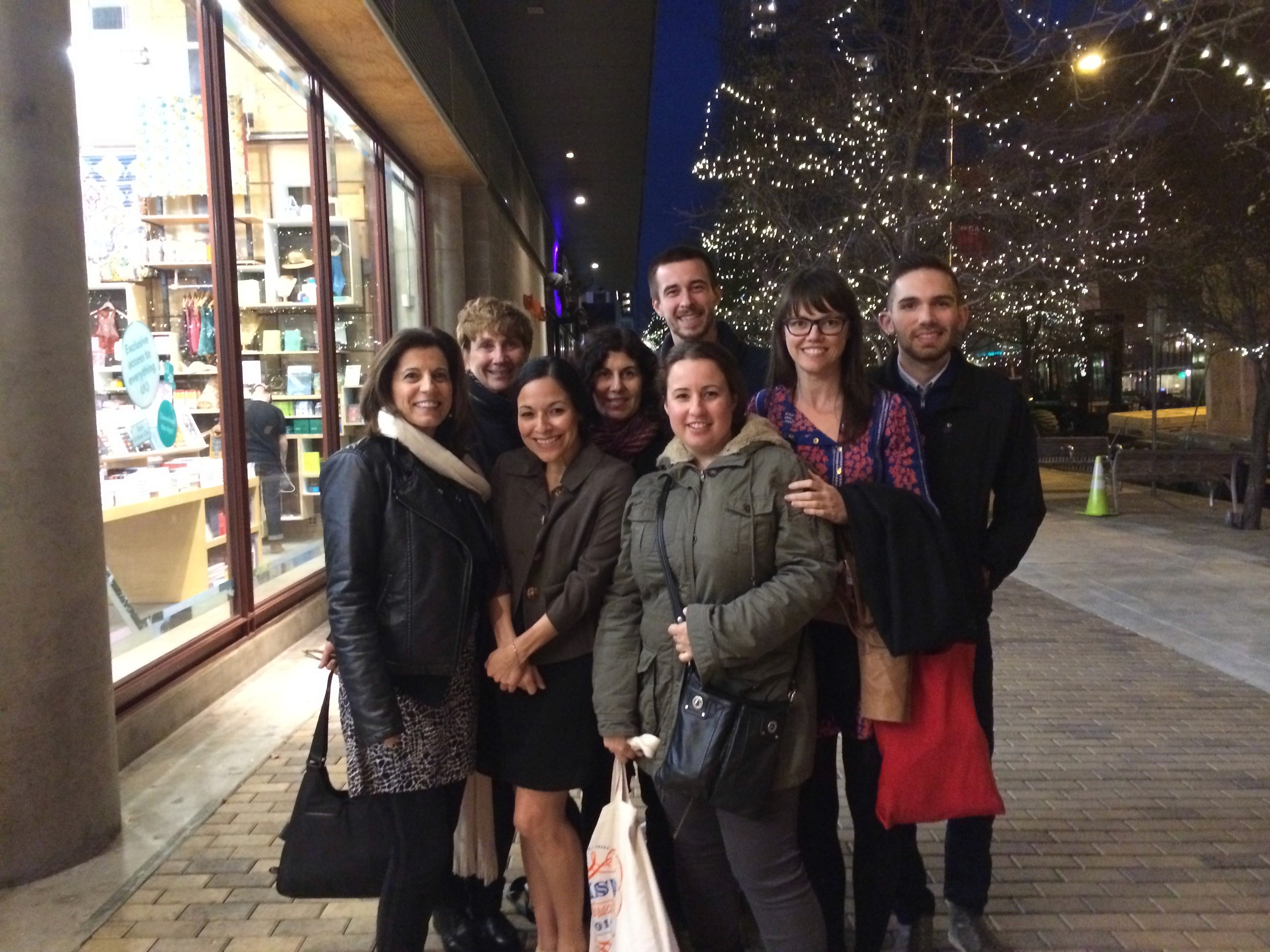 group photo of eight people on the sidewalk