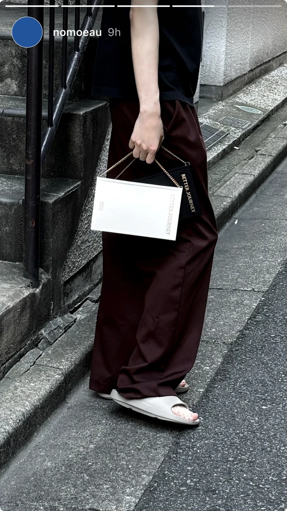 Person holding a white BETTER JOURNEY Creative Journal while walking, demonstrating its portability and stylish design complementing casual attire