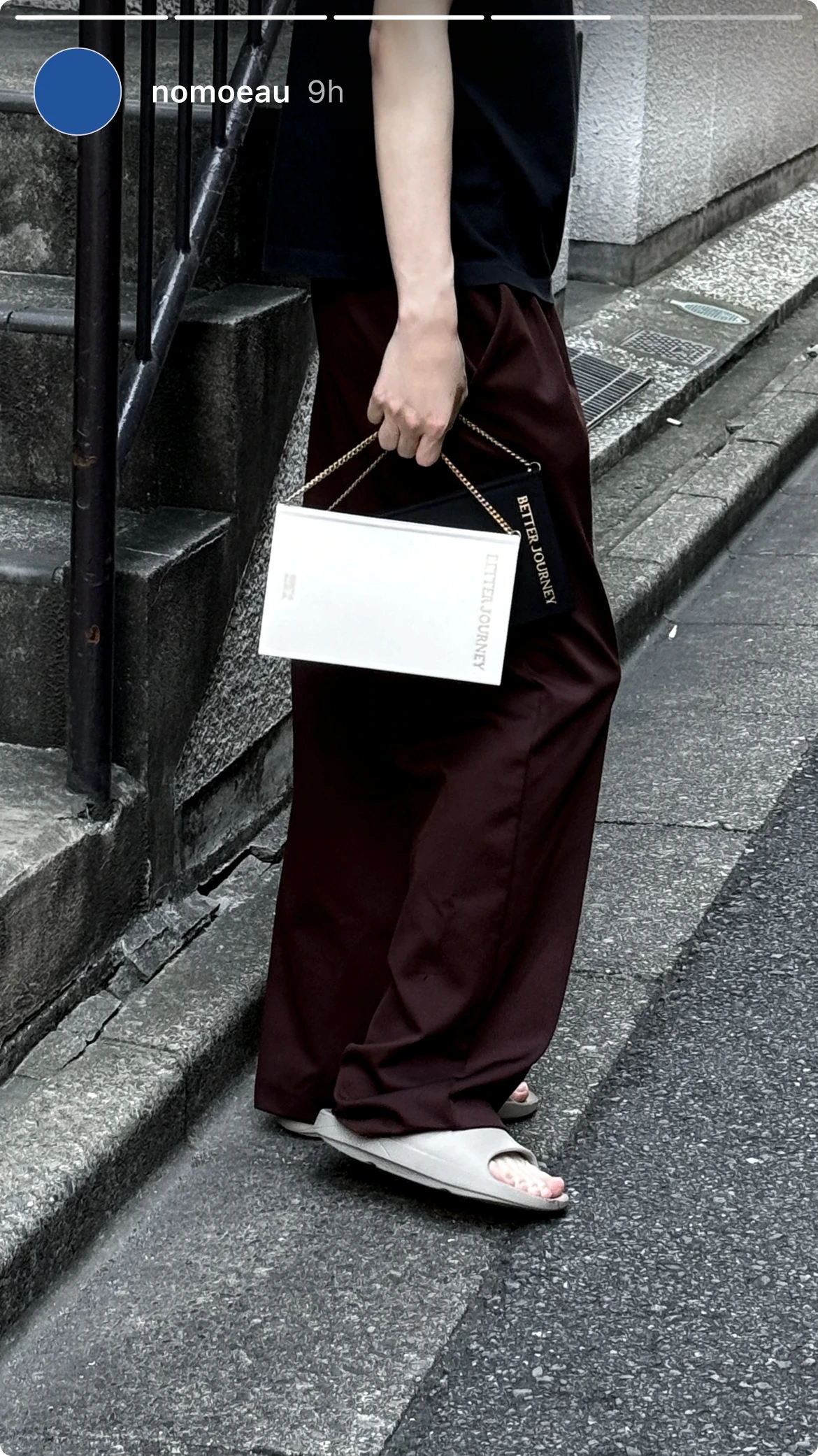Person holding a white BETTER JOURNEY Creative Journal while walking, demonstrating its portability and stylish design complementing casual attire