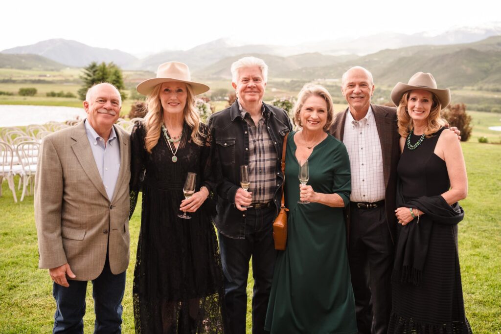 Guests posing for a group photo at an outdoor mountain event, illustrating the candid, natural style often seen when comparing Photo Booth vs Roaming Photographer experiences
