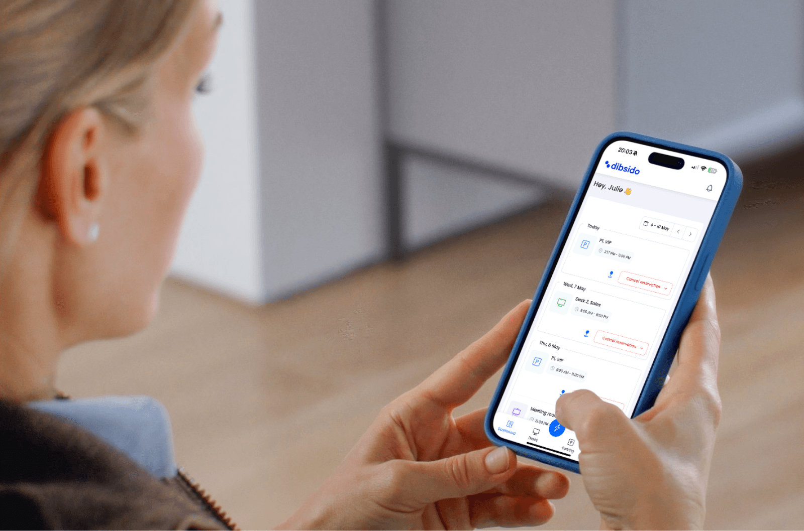 woman using desk booking app on her phone