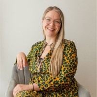 A woman wearing glasses and a sweater