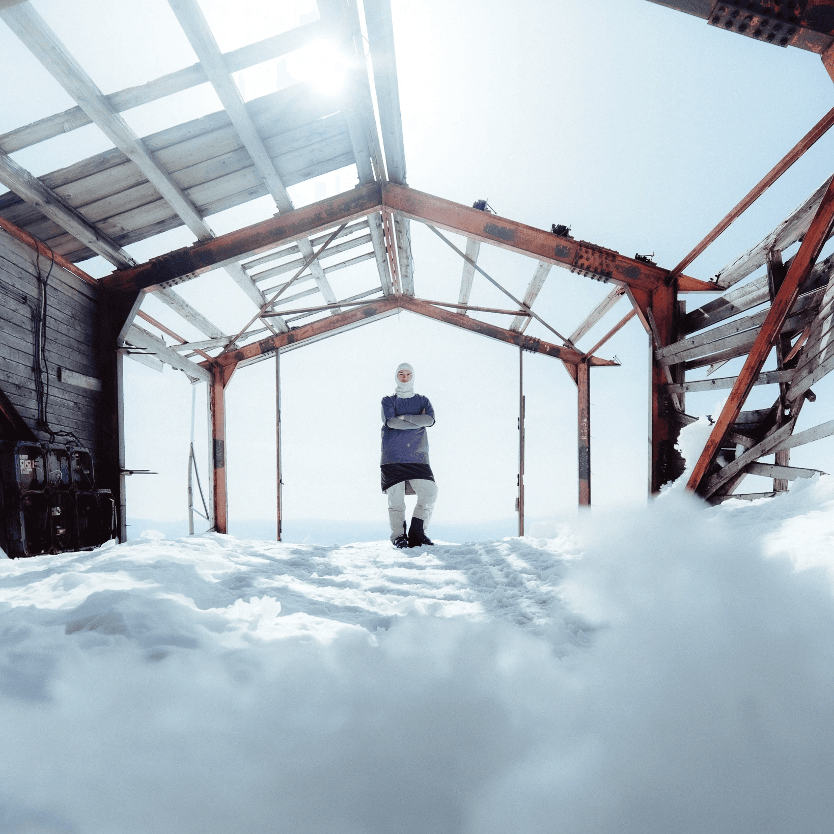 picture of a woman standing next to an old ski lift.