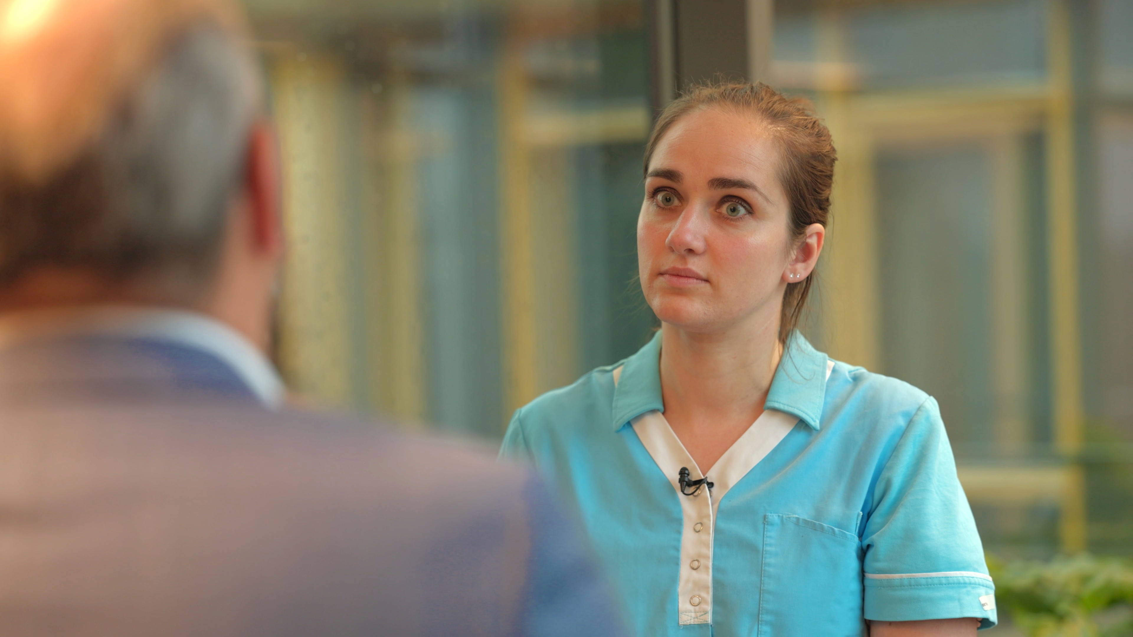 orgmedewerker in gesprek met bestuurder tijdens on-locatie opname externe communicatievideo zorgsector