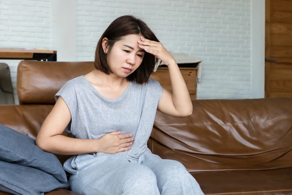 women holding gut and brain in distress