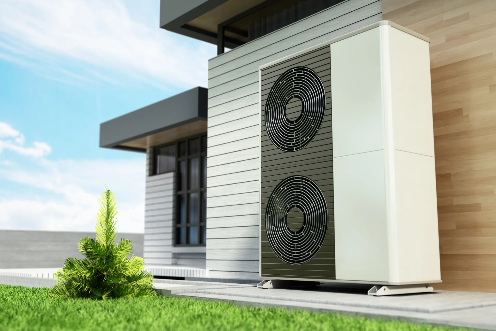 Eine Wärmepumpe vor einer Hauswand auf einem Beton-Plateu.