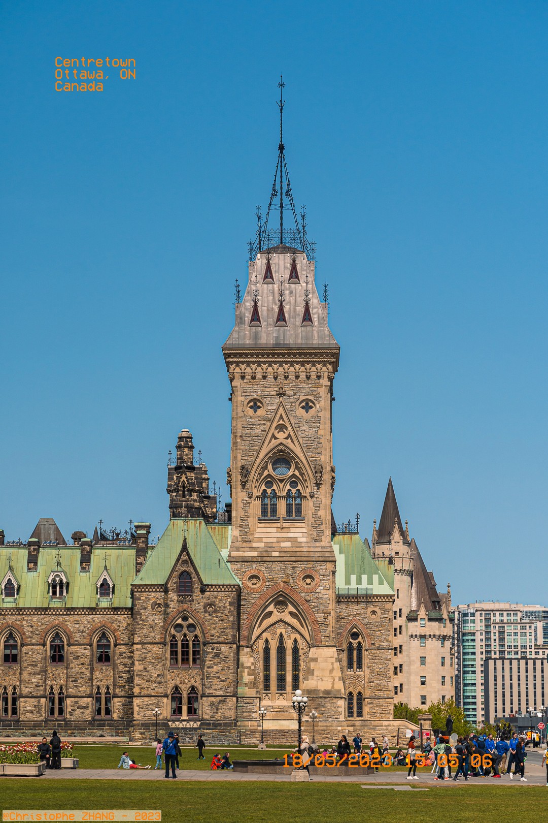 Visiteurs profitant du terrain du Parlement à Ottawa sous un ciel bleu.