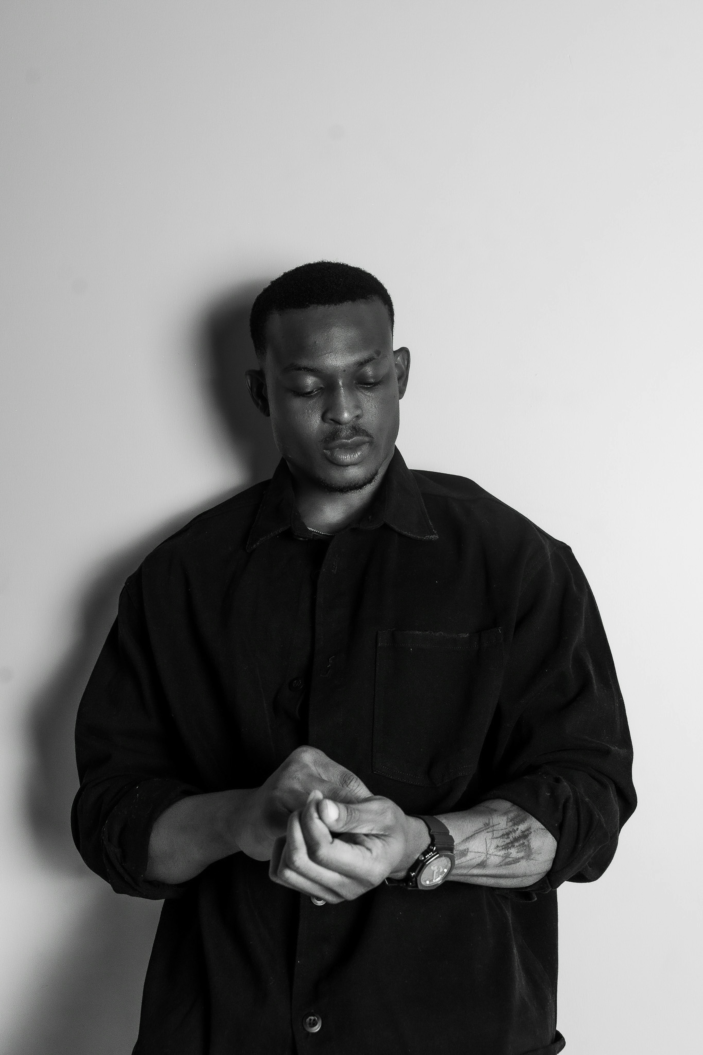 Man in dark shirt with hands clasped