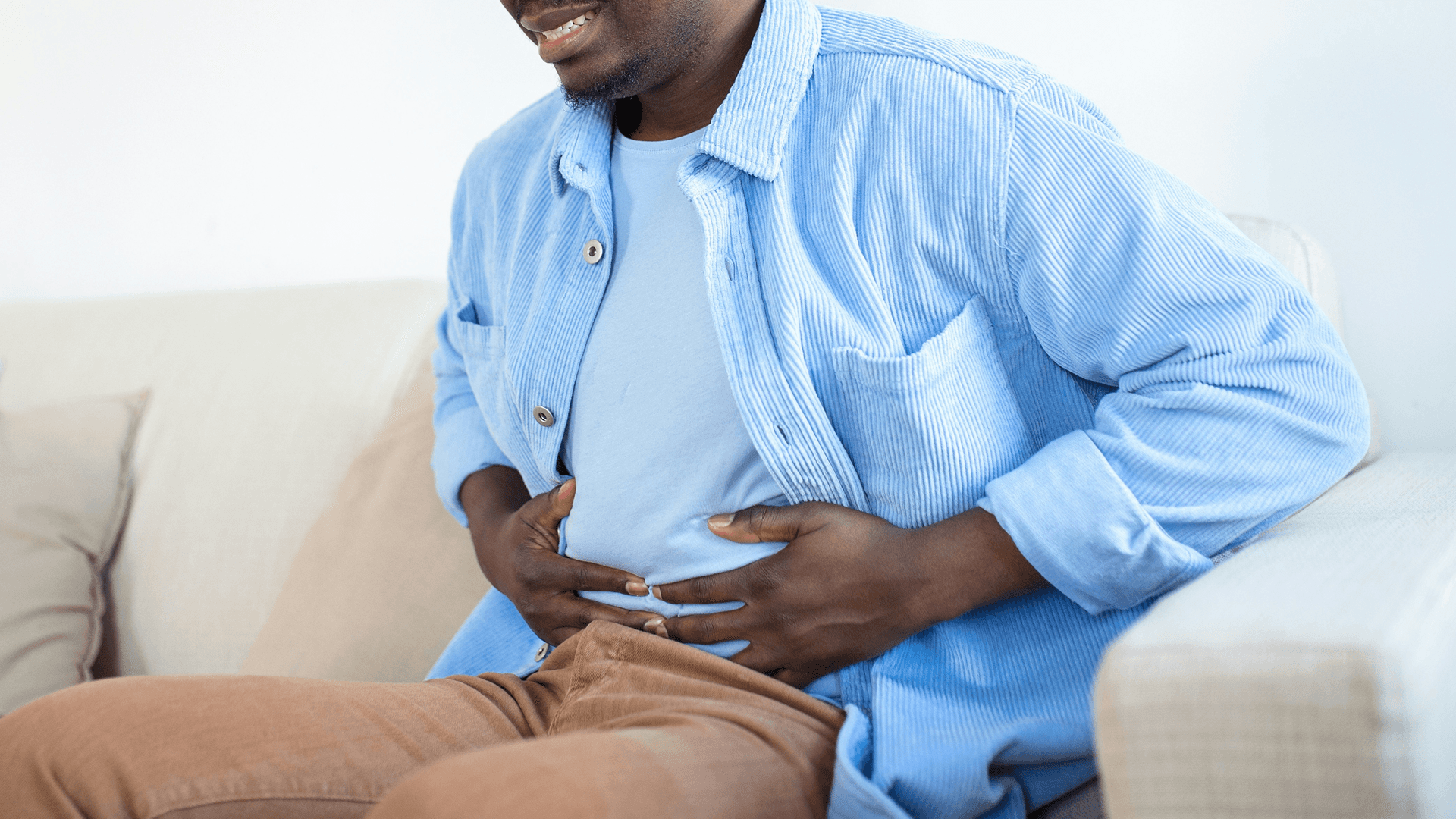 Man sitting and holding his stomach - Why Do GLP1 Cause Nausea