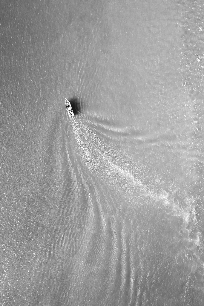 Aerial view of clear turquoise waters in the Fiji Islands with boat, luxury destination for private jet charter flights and helicopter transfers across Fiji