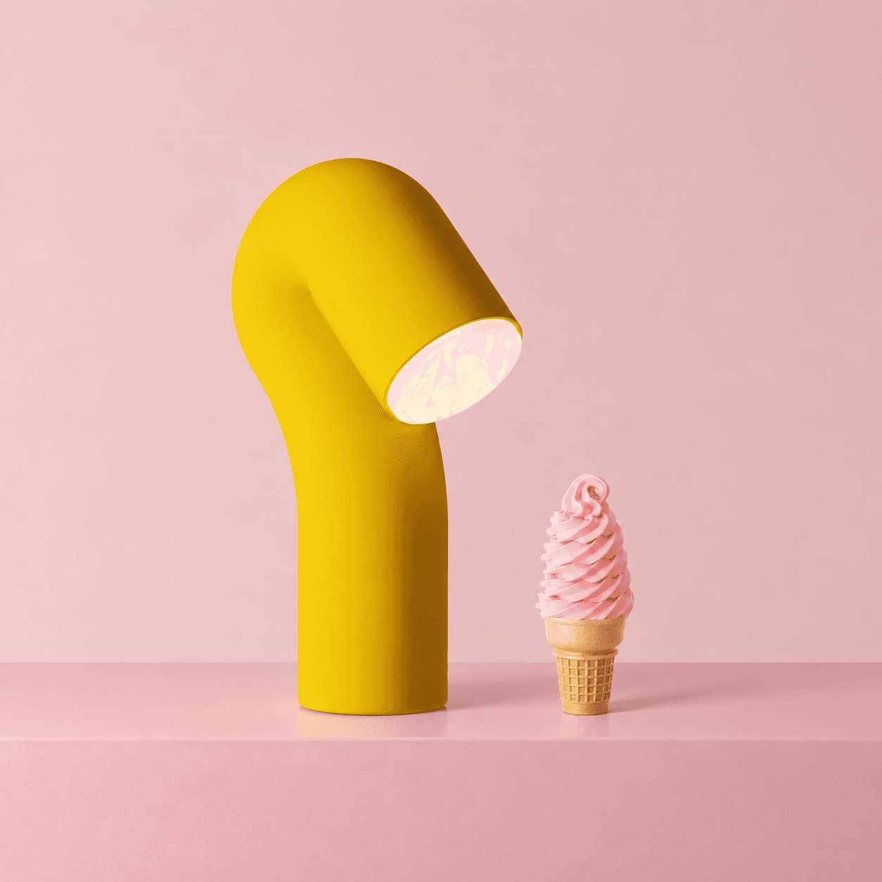 A yellow Smoothy lamp for Gantri leaning toward a pink soft serve cone