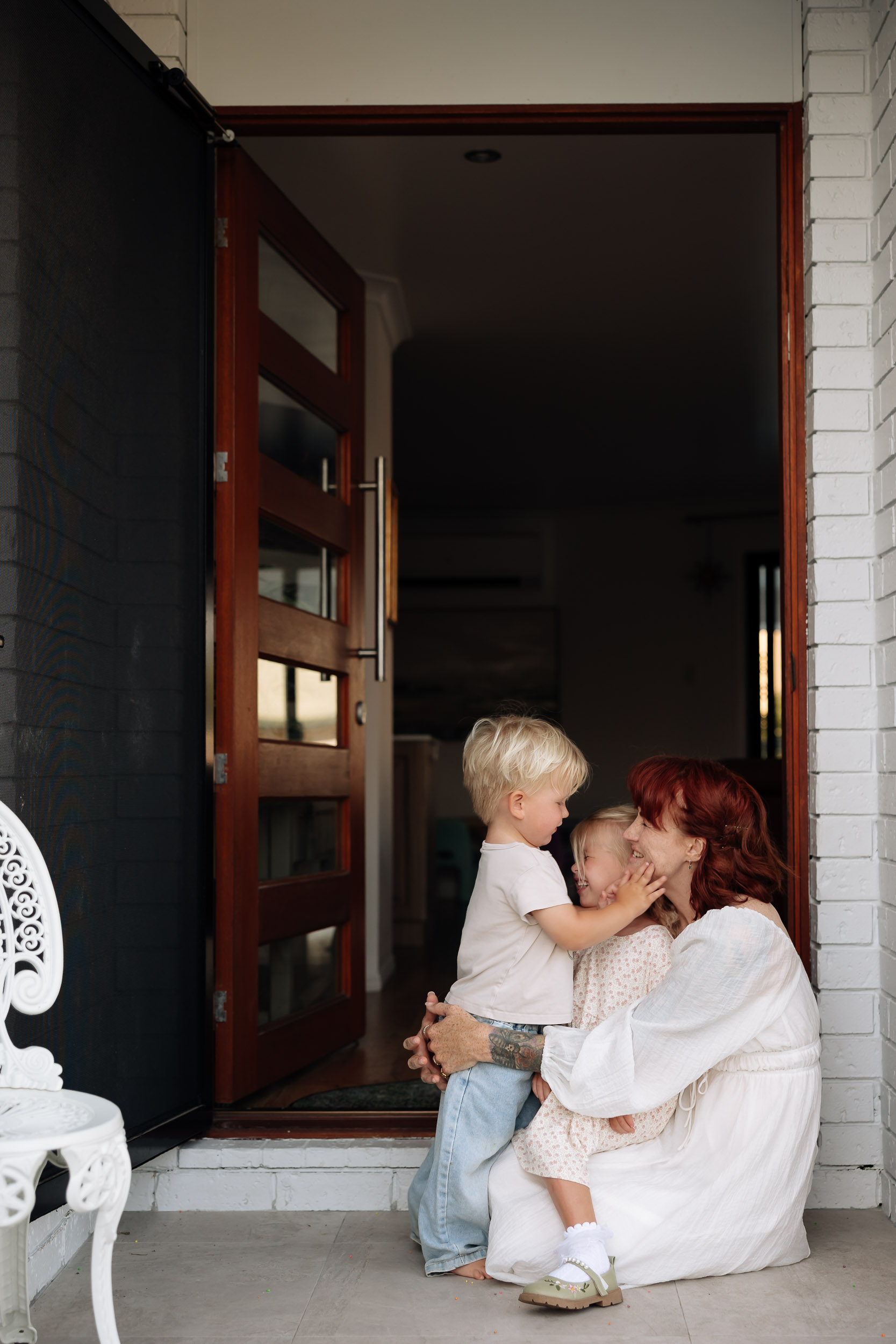Soft natural light image of mother and toddler connecting at home entrance in Mackay