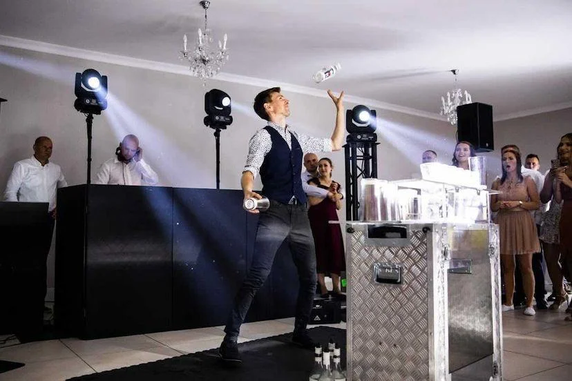 Atrakcje weselne – barman wykonuje pokaz barmański na mobilnym barze.
