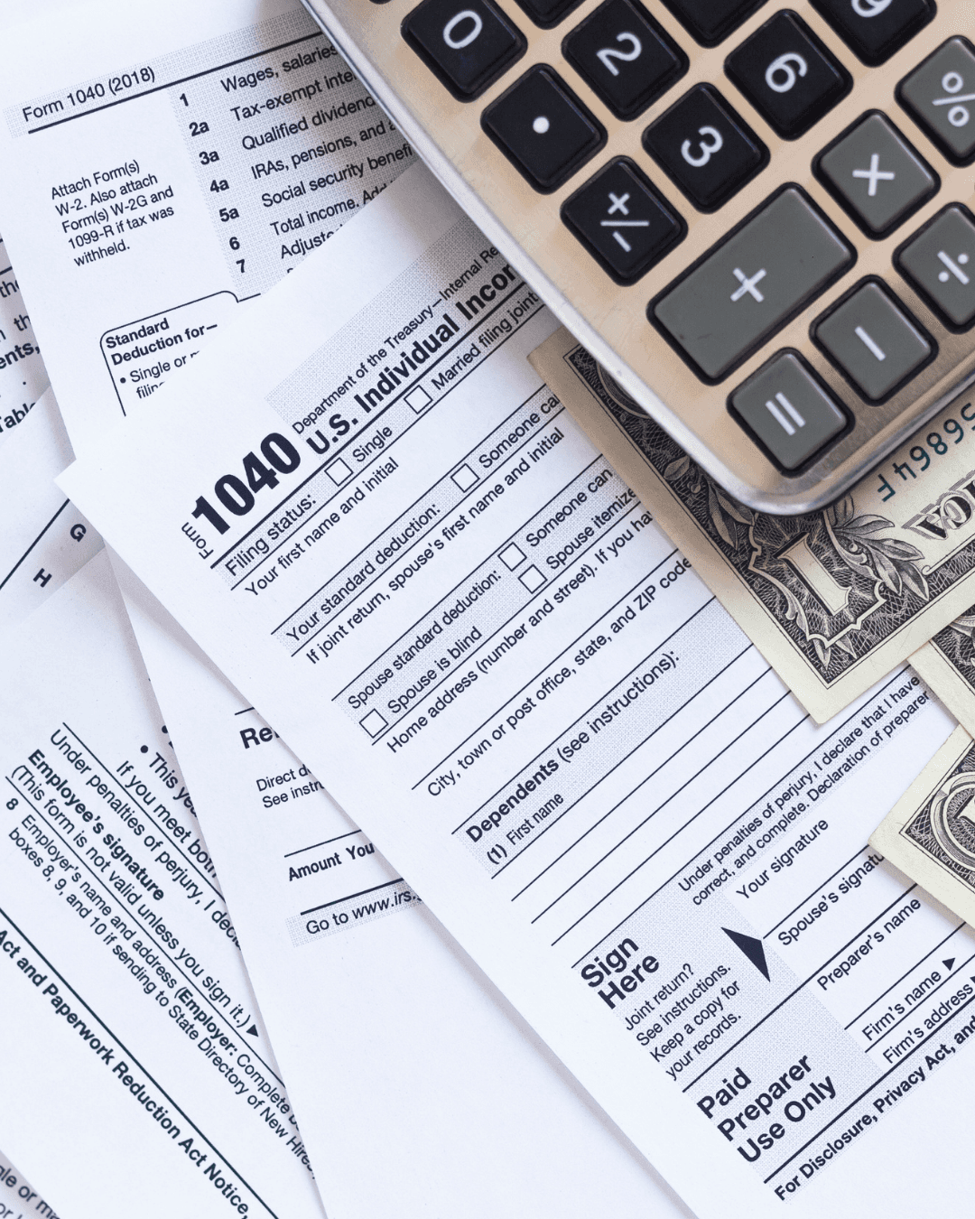 A woman with curly hair wearing a white blouse holds a clipboard with colorful graphs and charts, sitting in a well-lit modern office space.