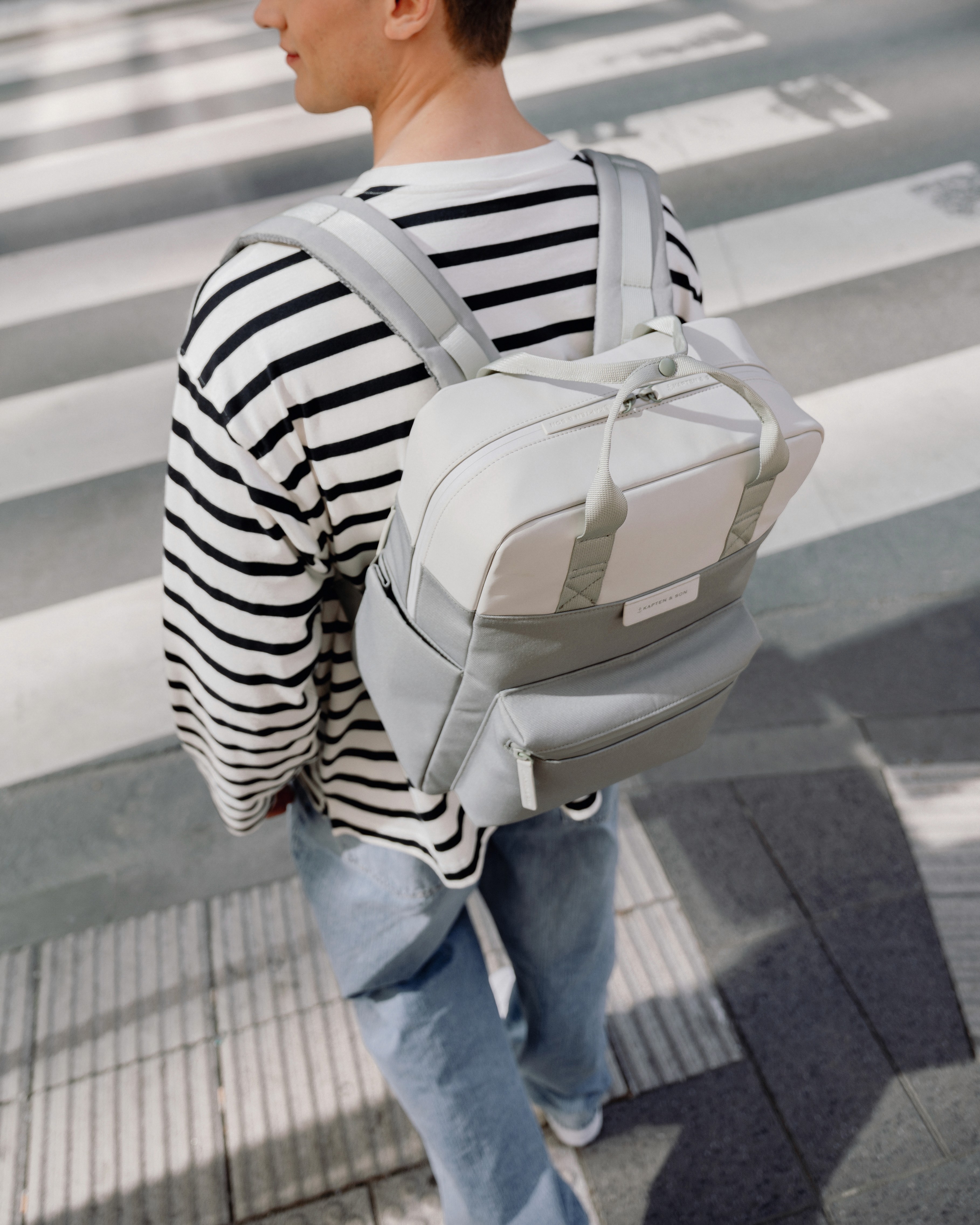 Un mannequin porte un sac sur le dos, gris et blanc