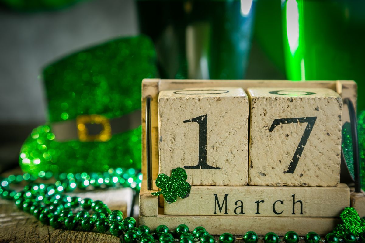 St. Patrick's Day hat and green beads next to a calendar highlighting March 17th, getting ready to celebrate the fun and festivities.