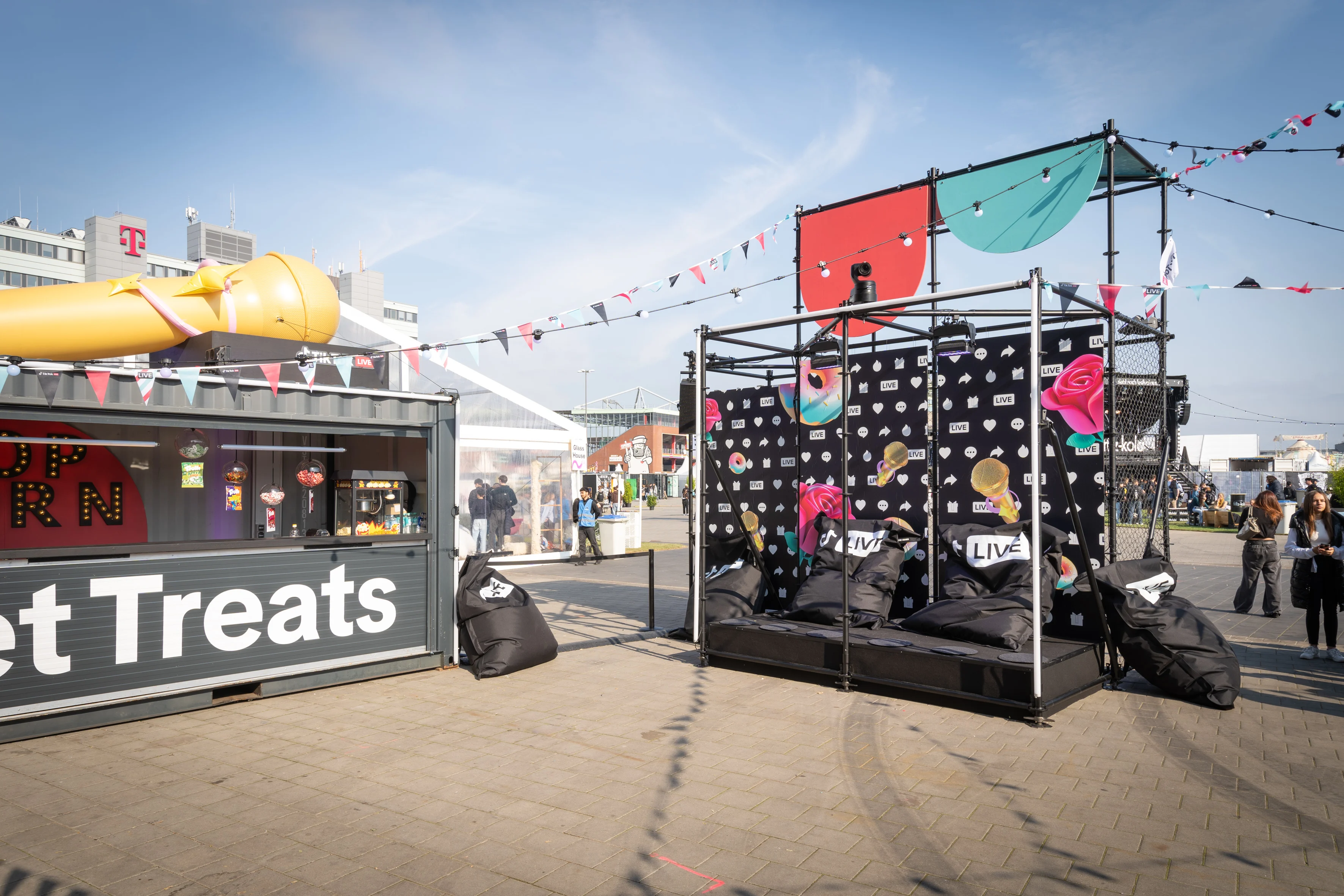 Open scaffold cube with black beanbags, patterned banners and bunting next to the snack container.