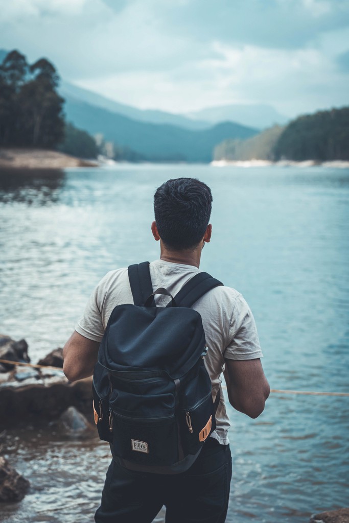 Person shown from behind looking at a lake.