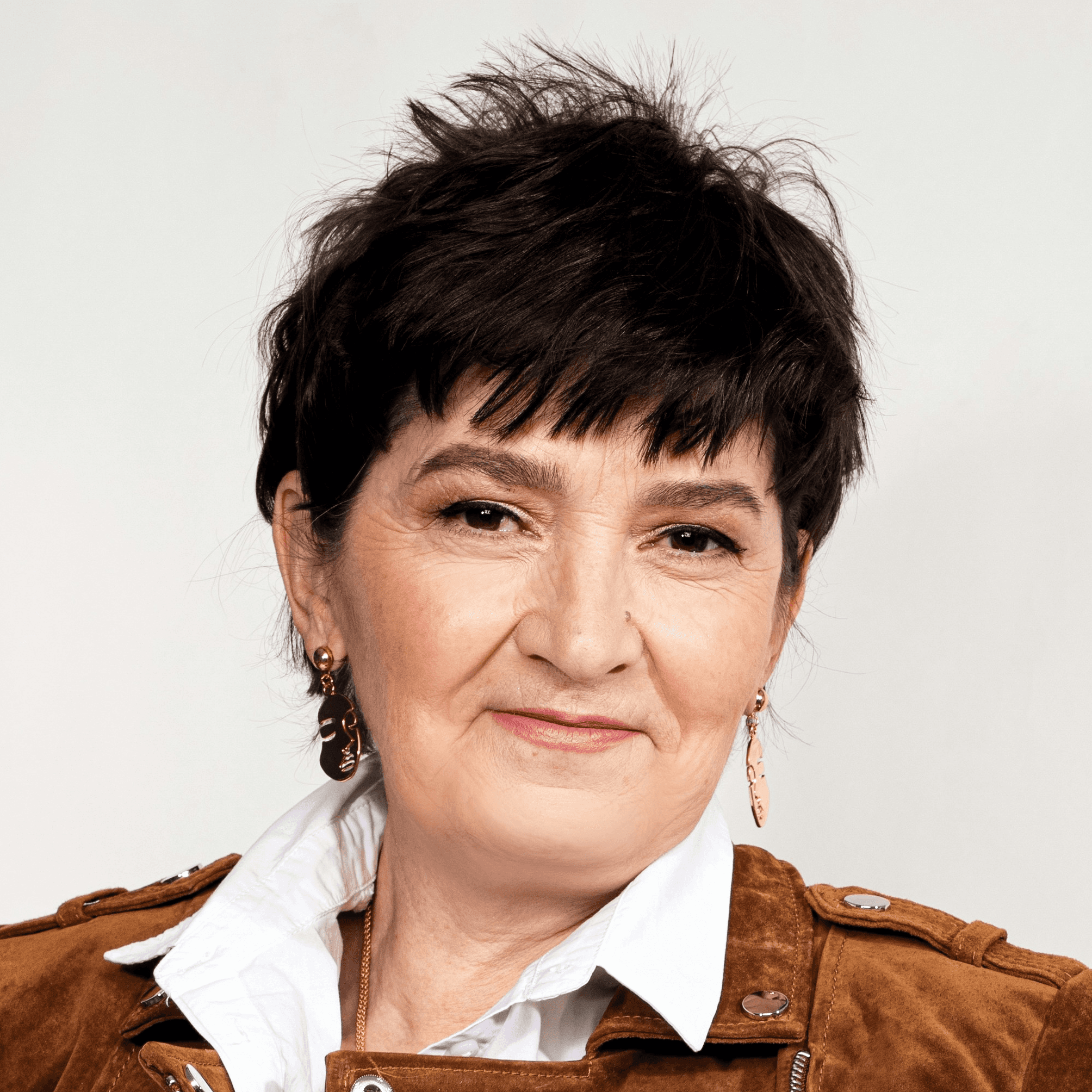 a woman in white pants and a brown jacket