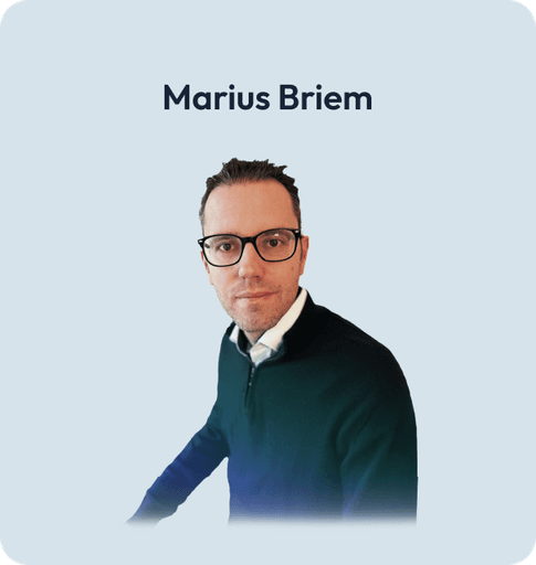 Porträt von Markus Briem, mit Brille und dunklem Blazer, mit ernstem Ausdruck.