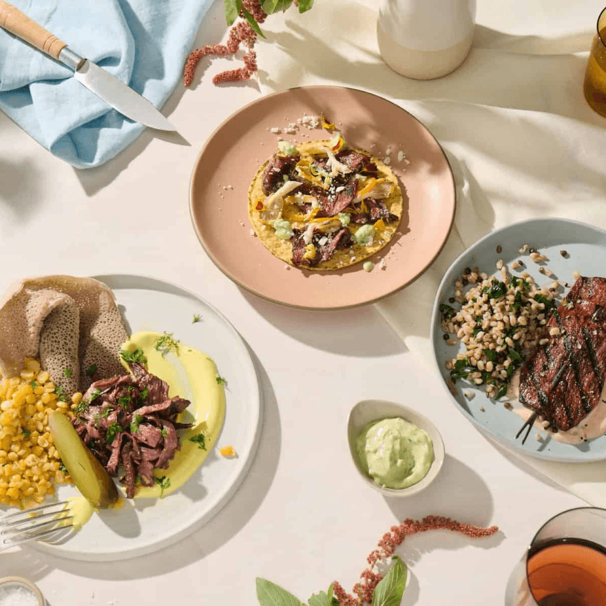 A table set with various plates of food and drinks.